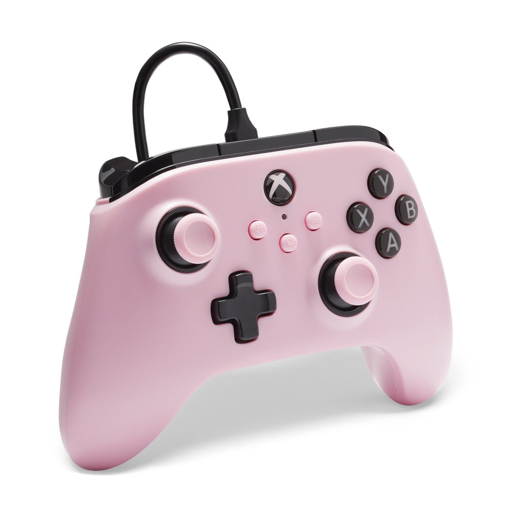 Różowy kontroler Xbox z czarnymi przyciskami i czarnym kablem.