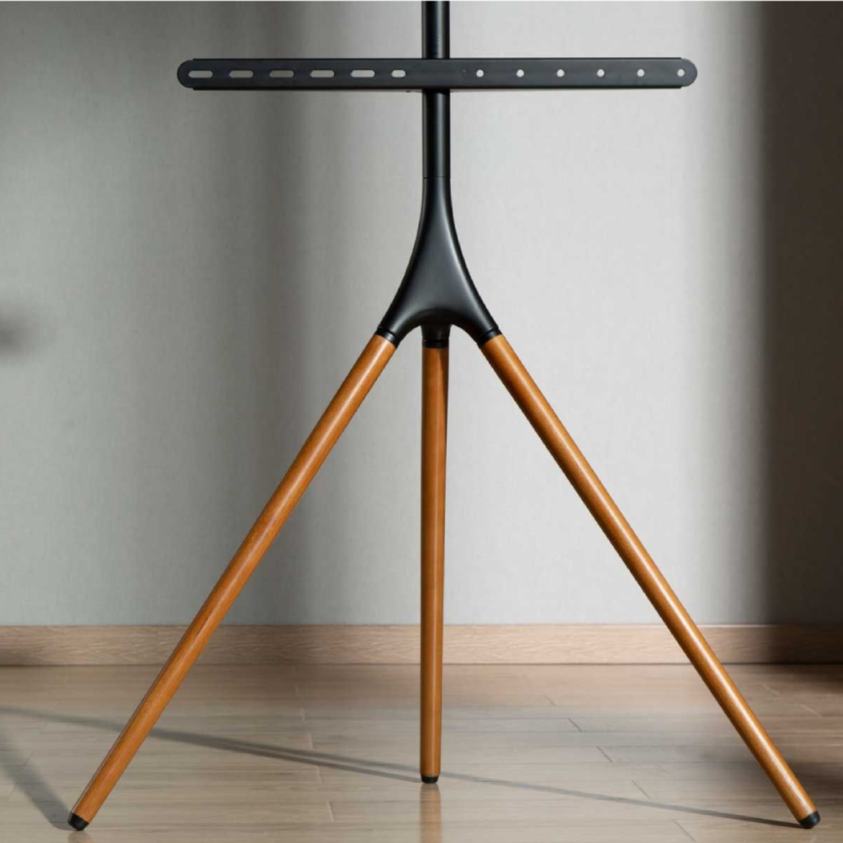 Un supporto TV nero con tre gambe in legno.