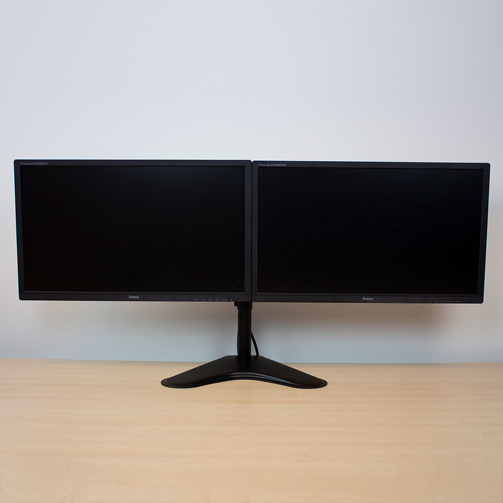 Due monitor neri sono uno accanto all'altro su una scrivania.
