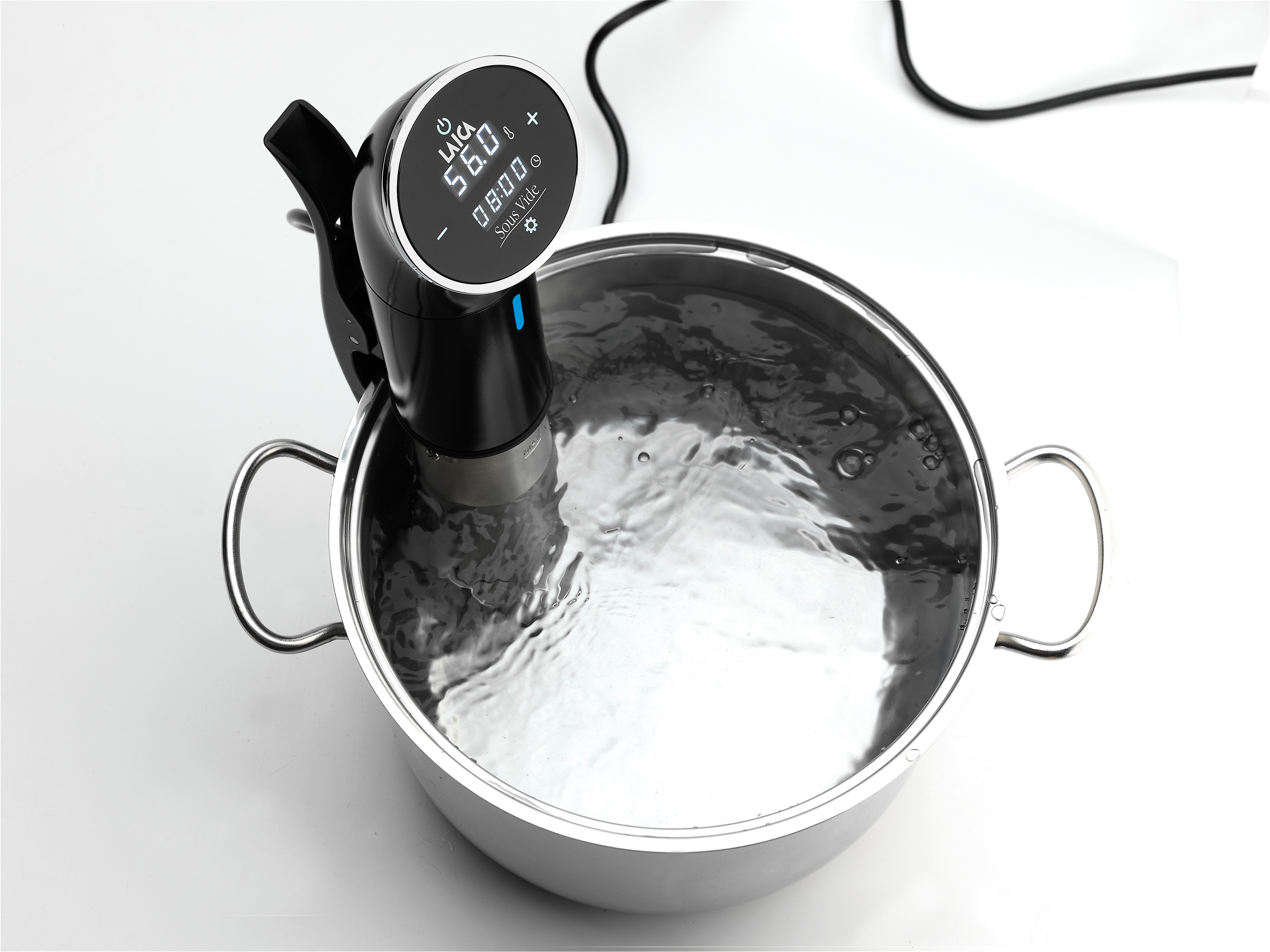 Una máquina de vacío negra en una olla de acero inoxidable con agua.
