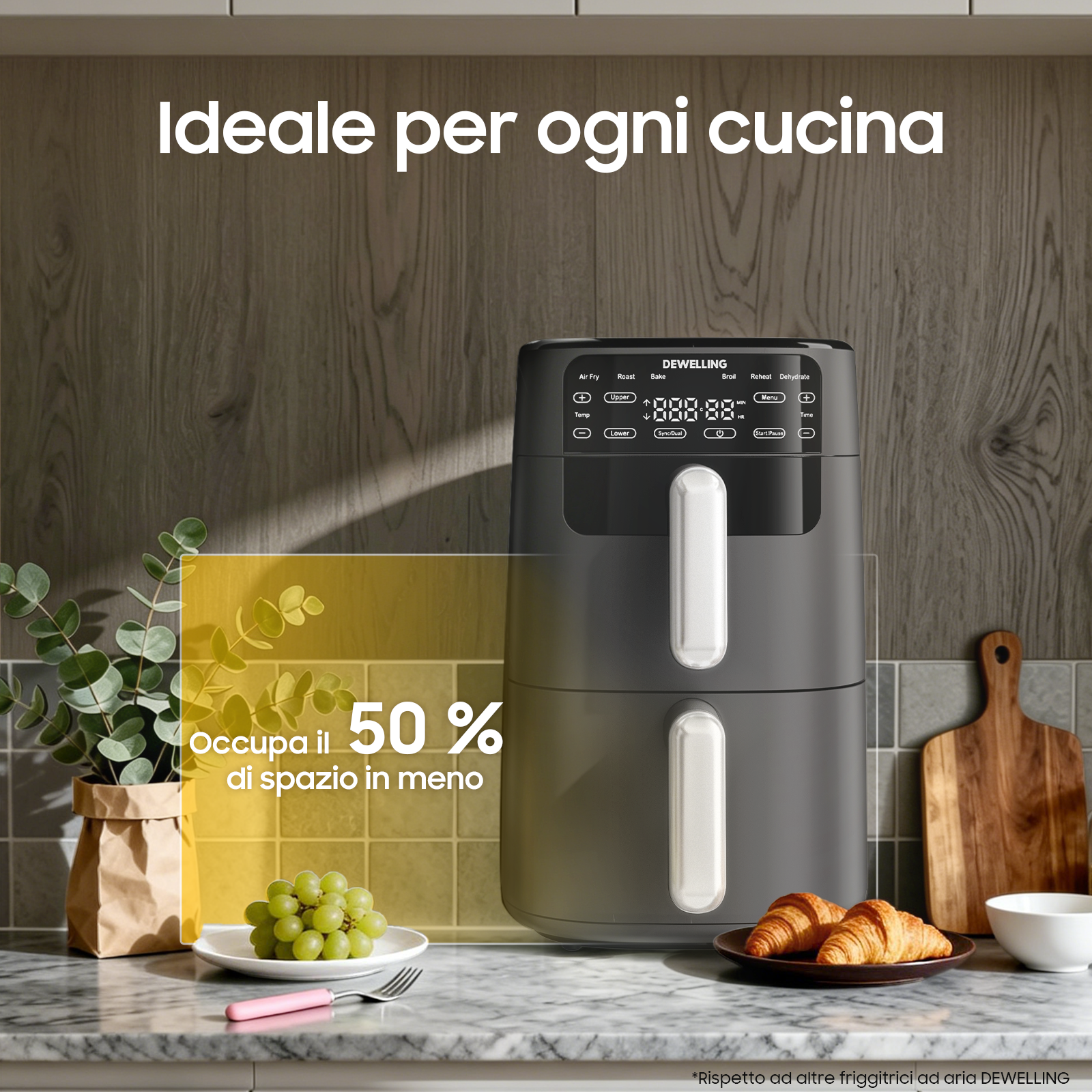 Una friggitrice ad aria Dwell nera su un piano di lavoro in marmo con uva e croissant.