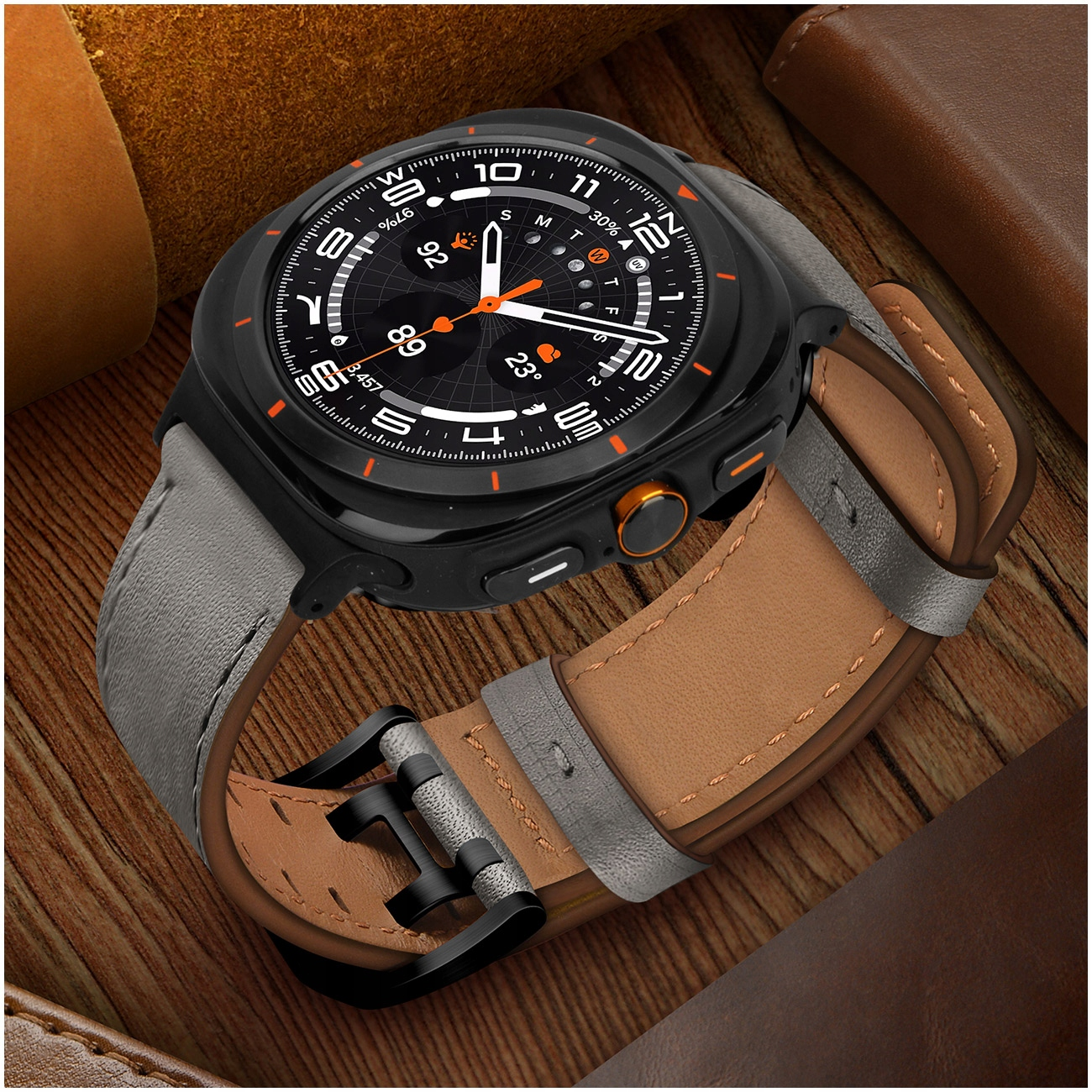 Zegarek smartwatch z szarym skórzanym paskiem na drewnianym stole. Wyświetlacz pokazuje czas i pogodę.