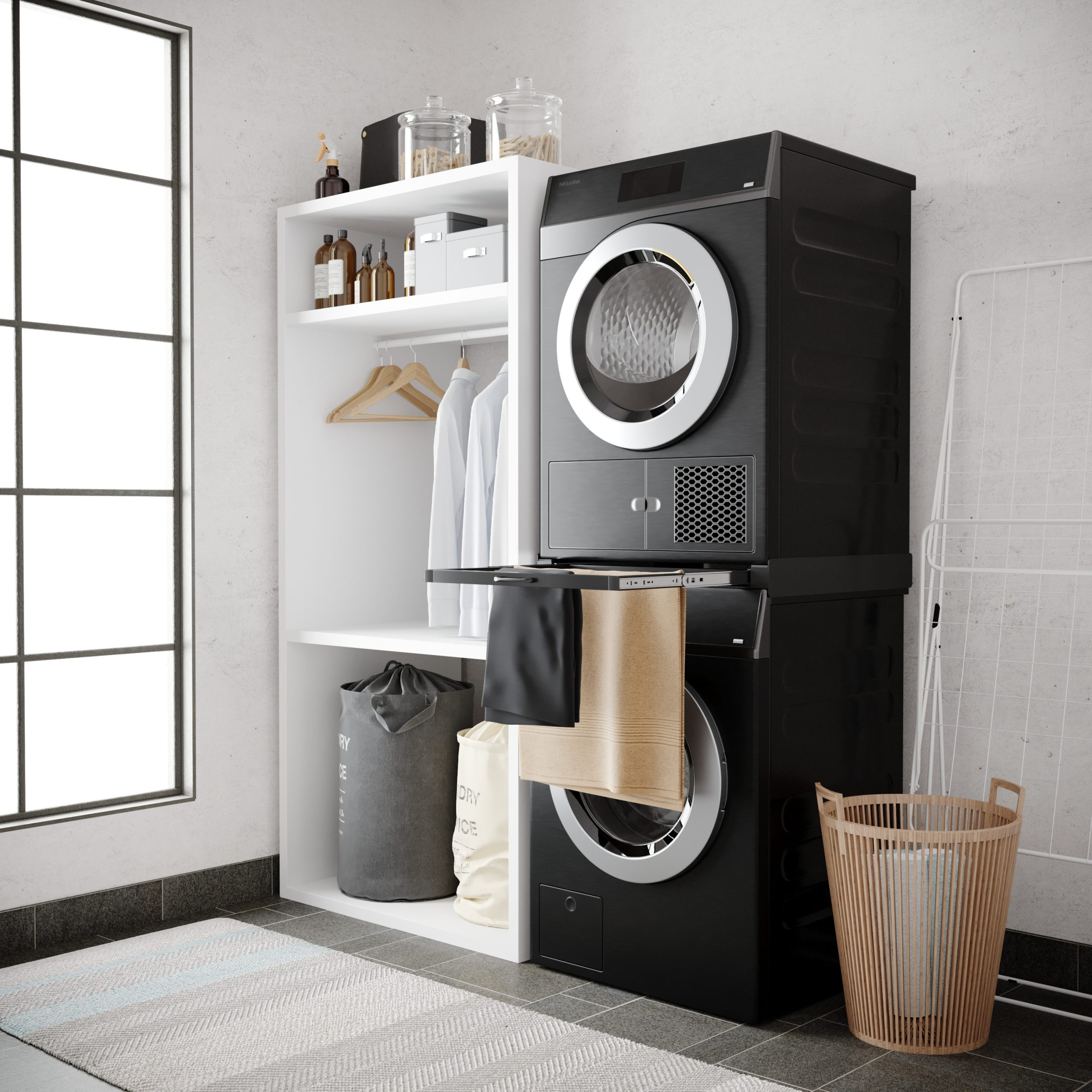 Black washer and dryer stacked on a rug. Left shelf holds laundry baskets and clothes.