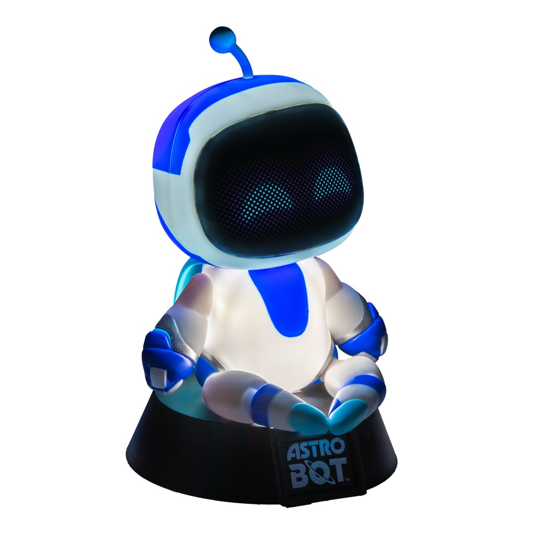 Astro Bot, niebiesko-biały robot ze świecącymi oczami, siedzi na czarnej podstawie.