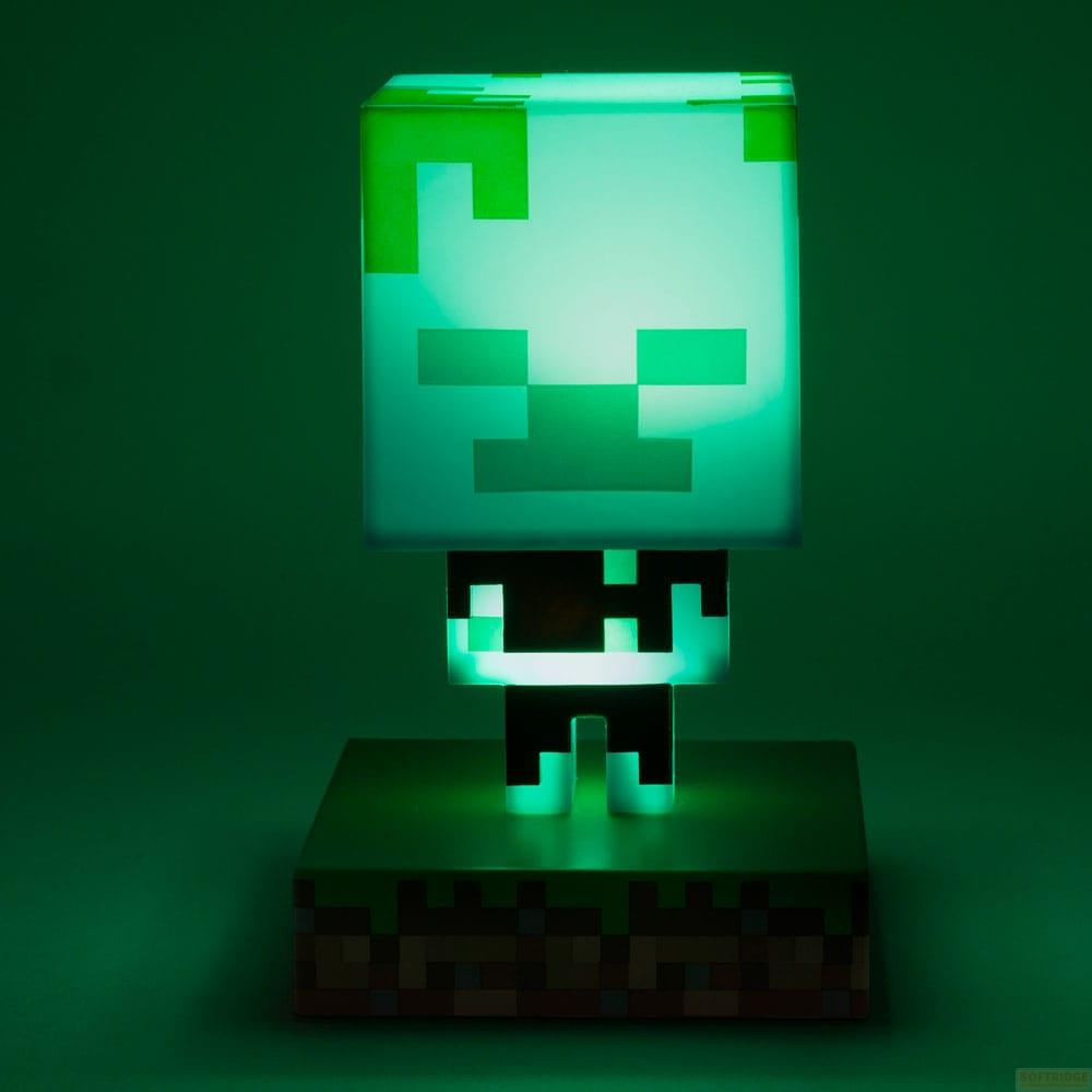 Zielony, świecący Creeper z Minecraft stoi na trawiastym podwyższeniu.