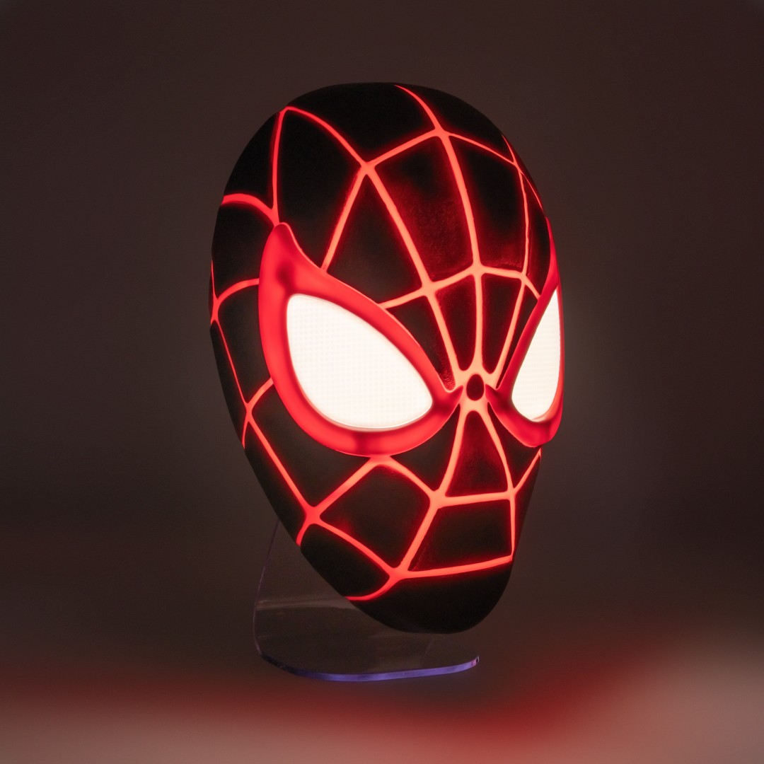 Czarna maska Spidermana z lśniącymi czerwonymi liniami i białymi oczami na ciemnym tle.