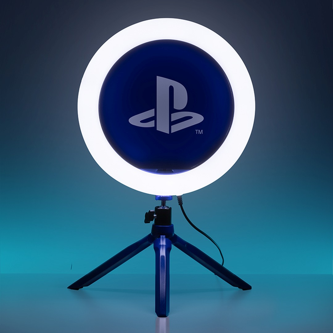 Lampka pierścieniowa z logo PlayStation stoi na niebieskim statywie na tle gradientu.