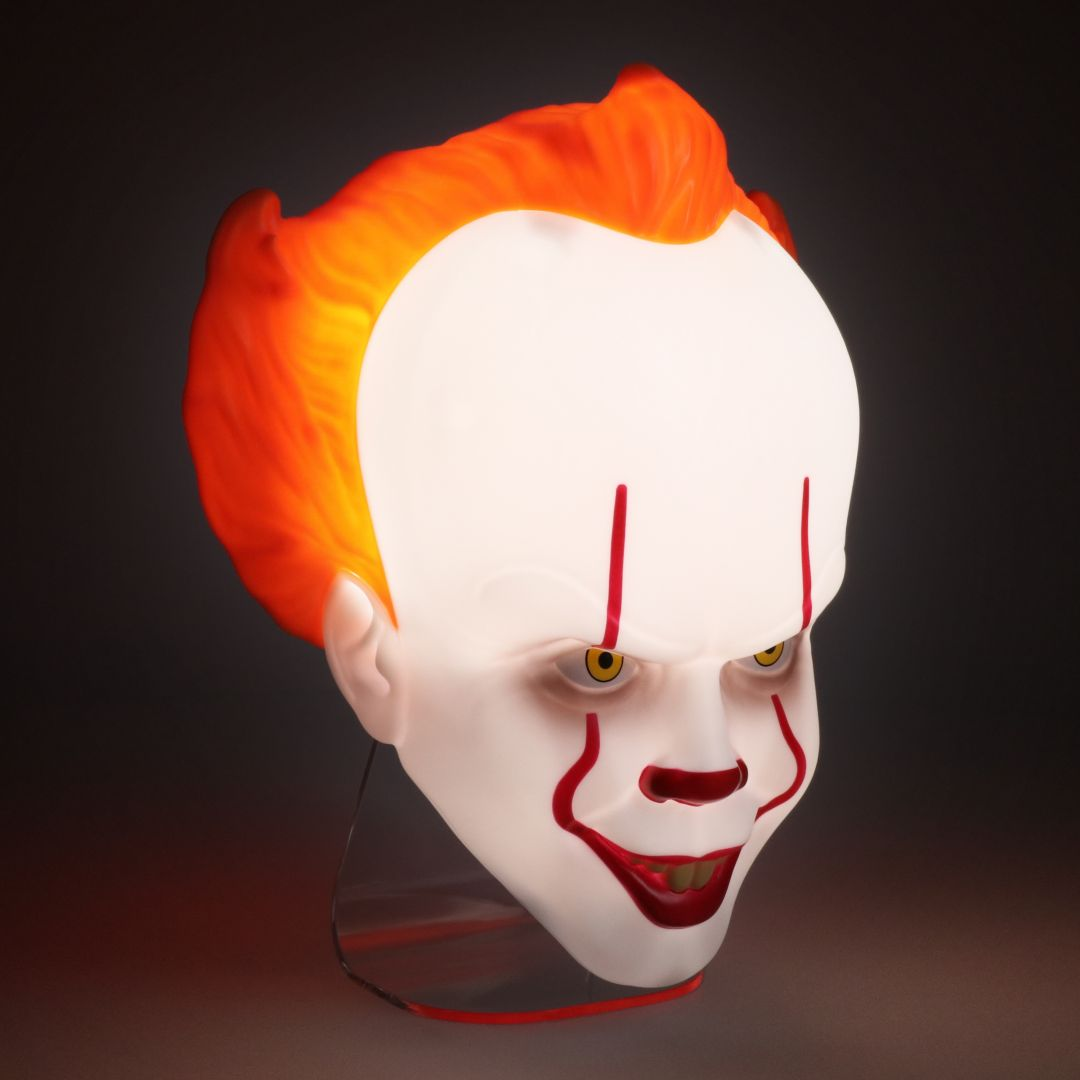 Świecąca maska Pennywise'a z pomarańczowymi włosami i czerwonymi znakami.