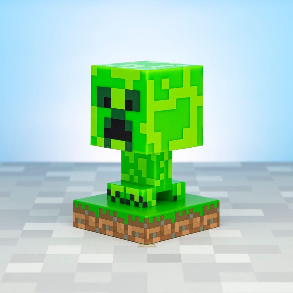 Zielona figurka Minecraft Creeper stoi na bloku trawy i ziemi.