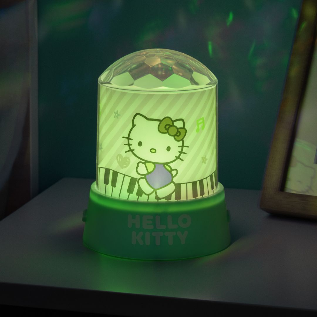 Lampa Hello Kitty z kulą dyskotekową na półce, emitująca zielone światło.