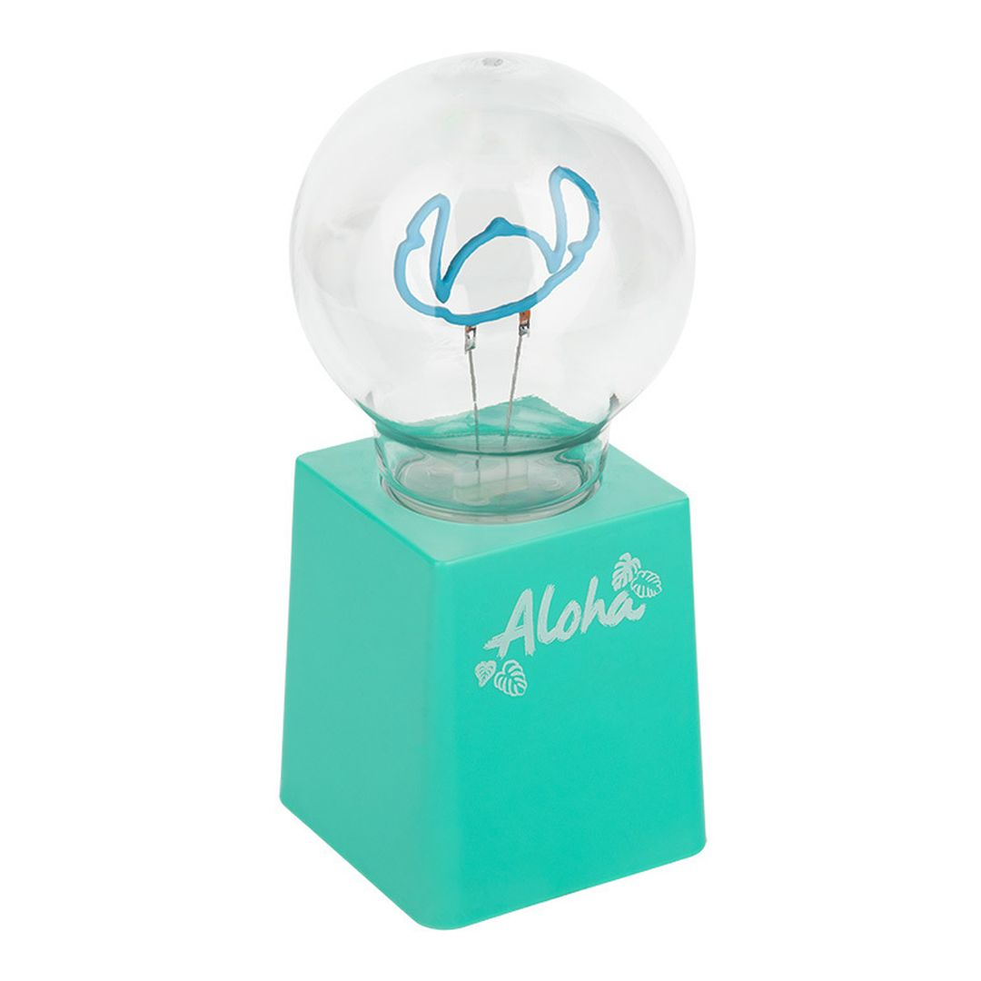 Turkusowa lampa z żarówką przedstawiającą Stitcha. Na podstawie ma napis 'Aloha'.