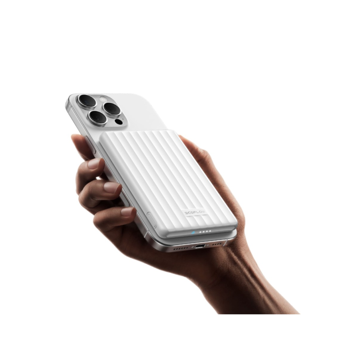 Una mano tiene uno smartphone bianco con una batteria esterna bianca attaccata.