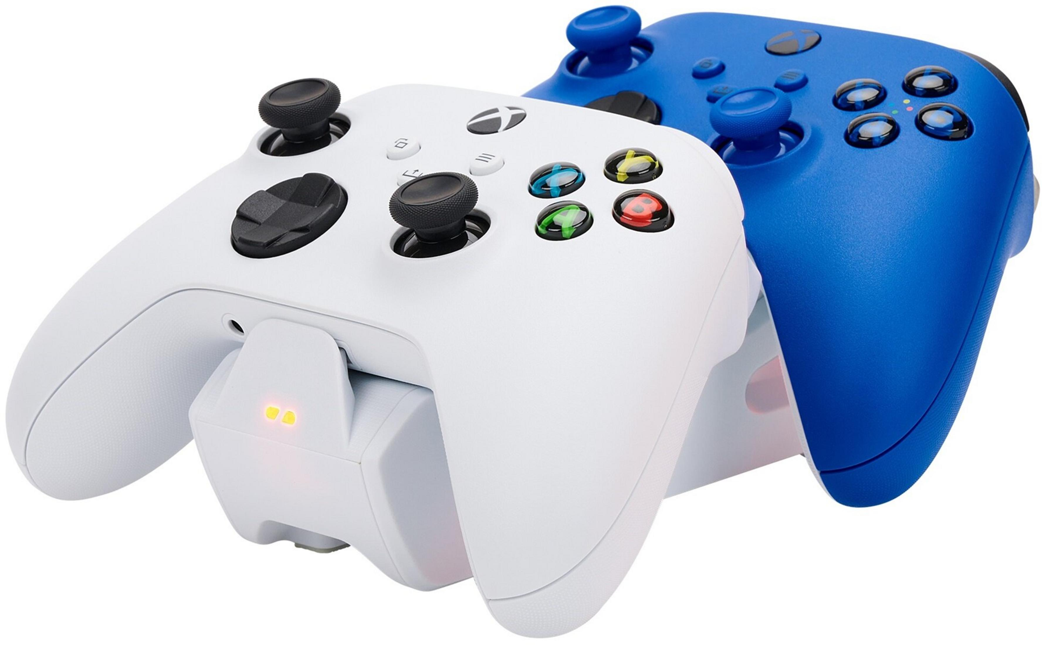 Biały i niebieski kontroler Xbox na stacji ładującej.