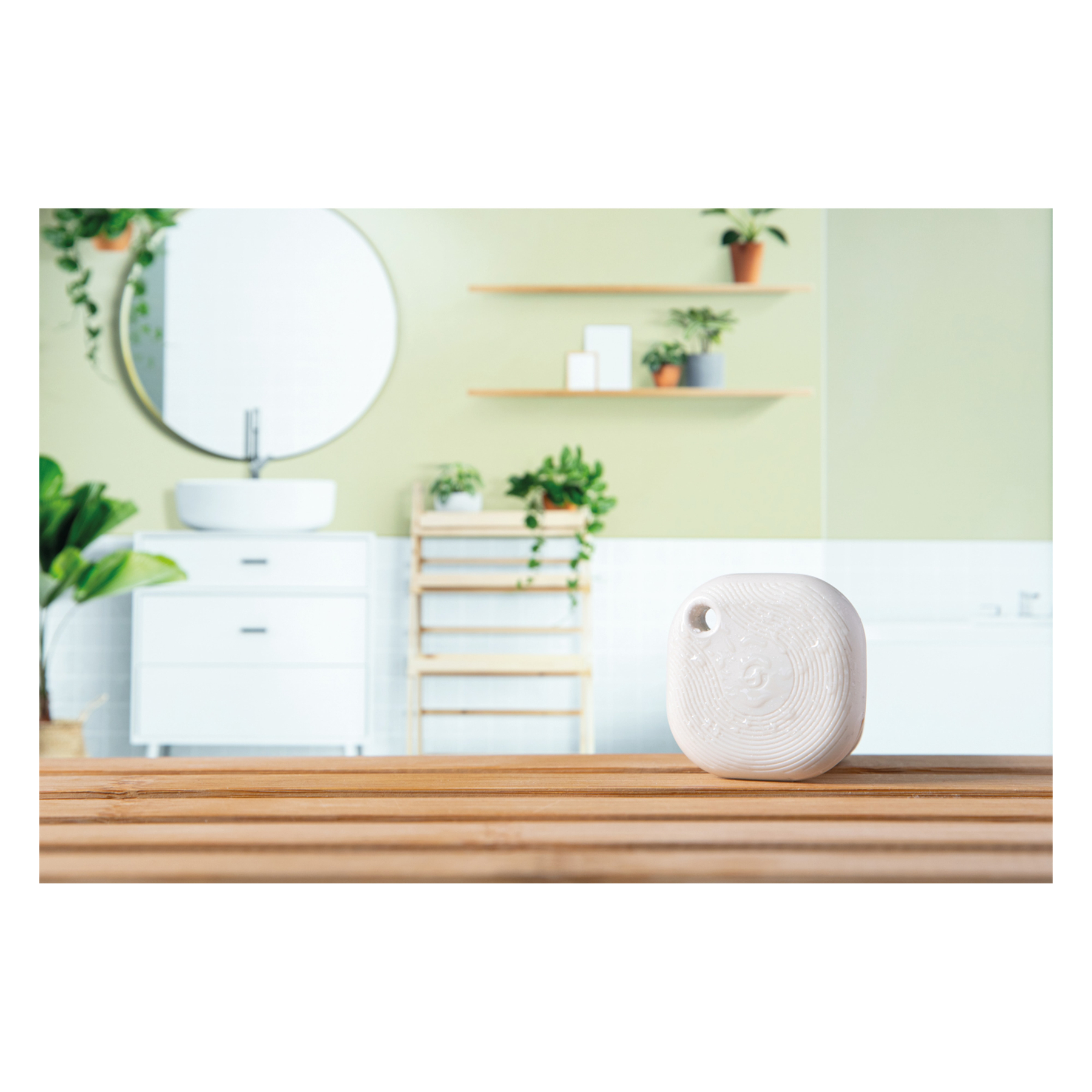 Objet blanc à motif circulaire sur table en bois devant une salle de bain.