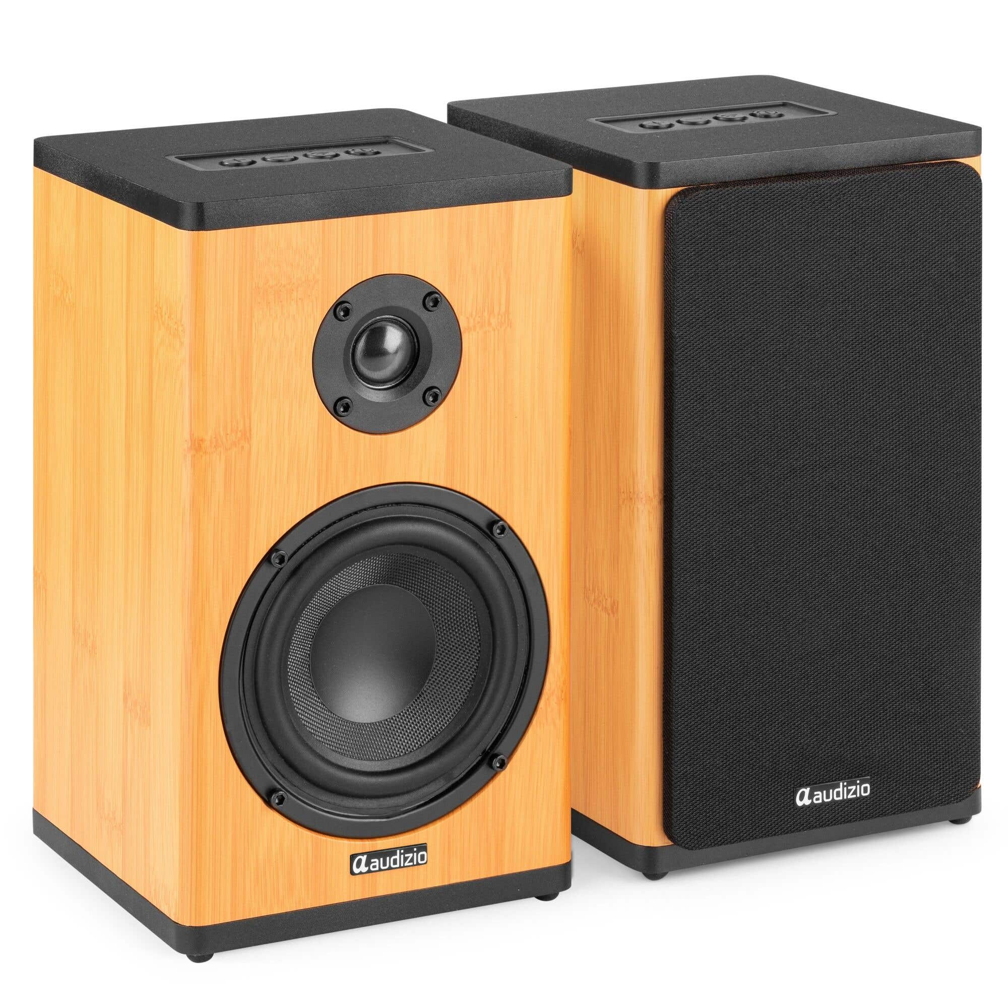 Dos altavoces de madera marrón con frentes negros y controles superiores.