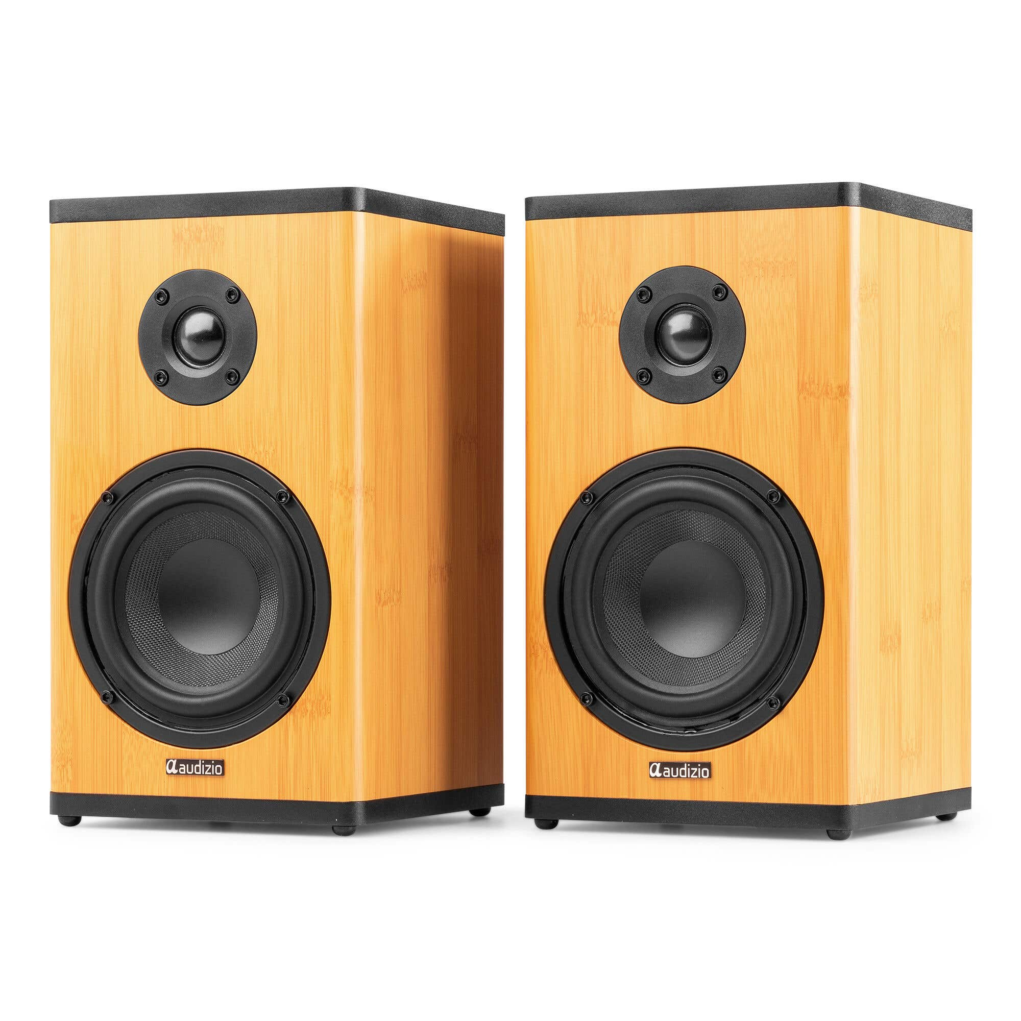 Dos altavoces de madera para estantería con ribete y altavoces negros sobre fondo blanco.