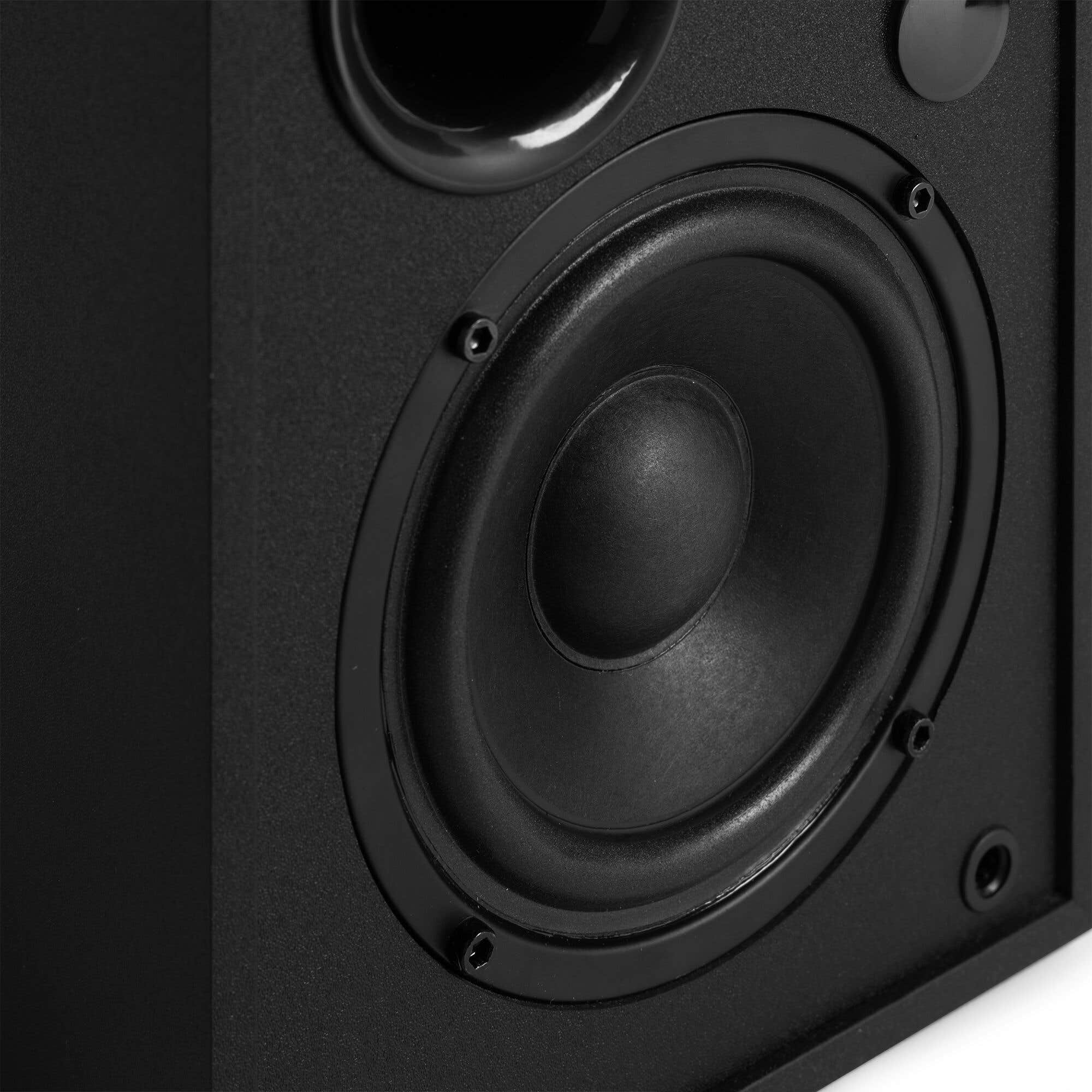Primer plano de un altavoz negro con cono y tweeter visibles. Gabinete texturizado negro.