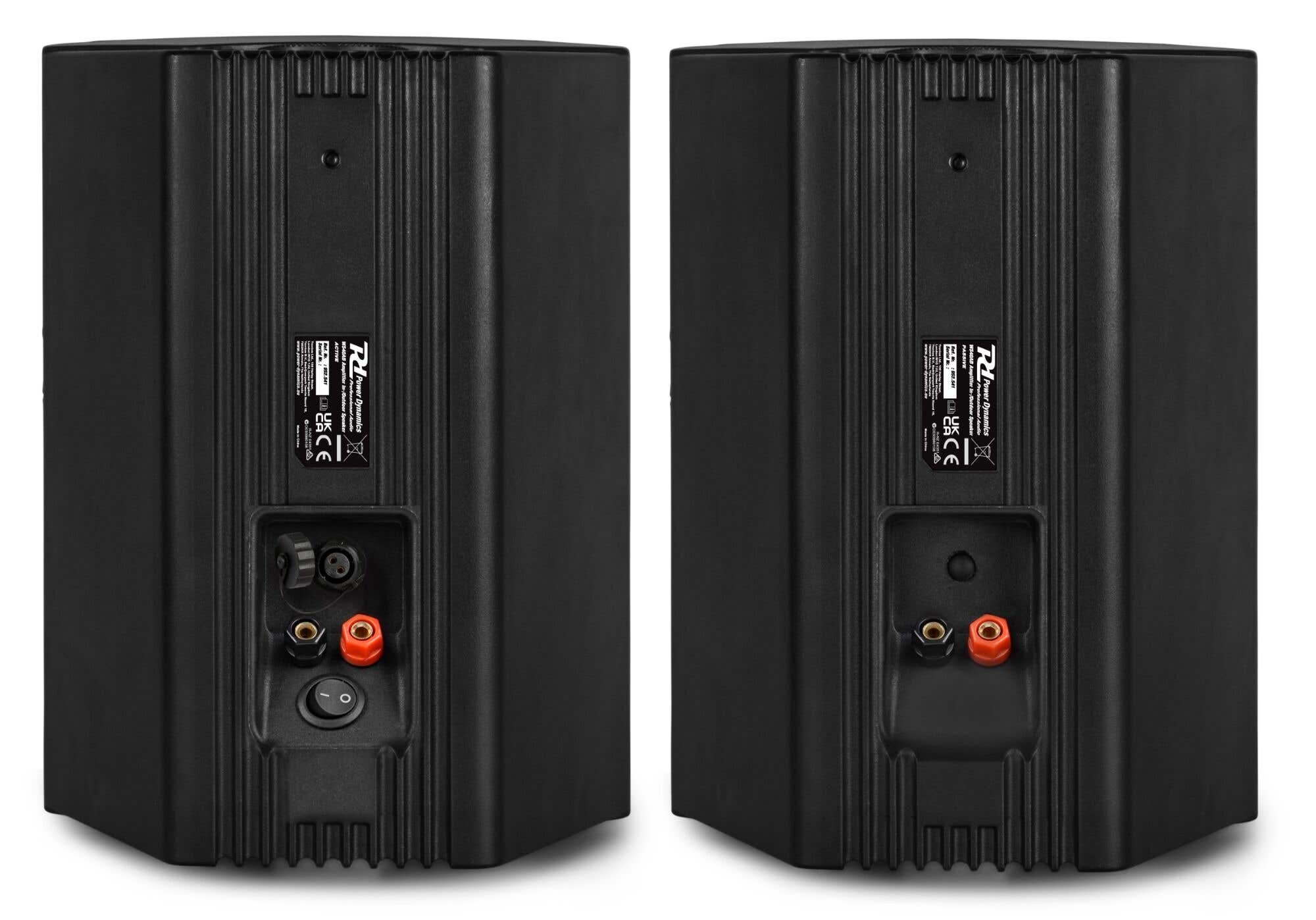 Dos altavoces negros vistos por detrás, mostrando conexiones y un interruptor.