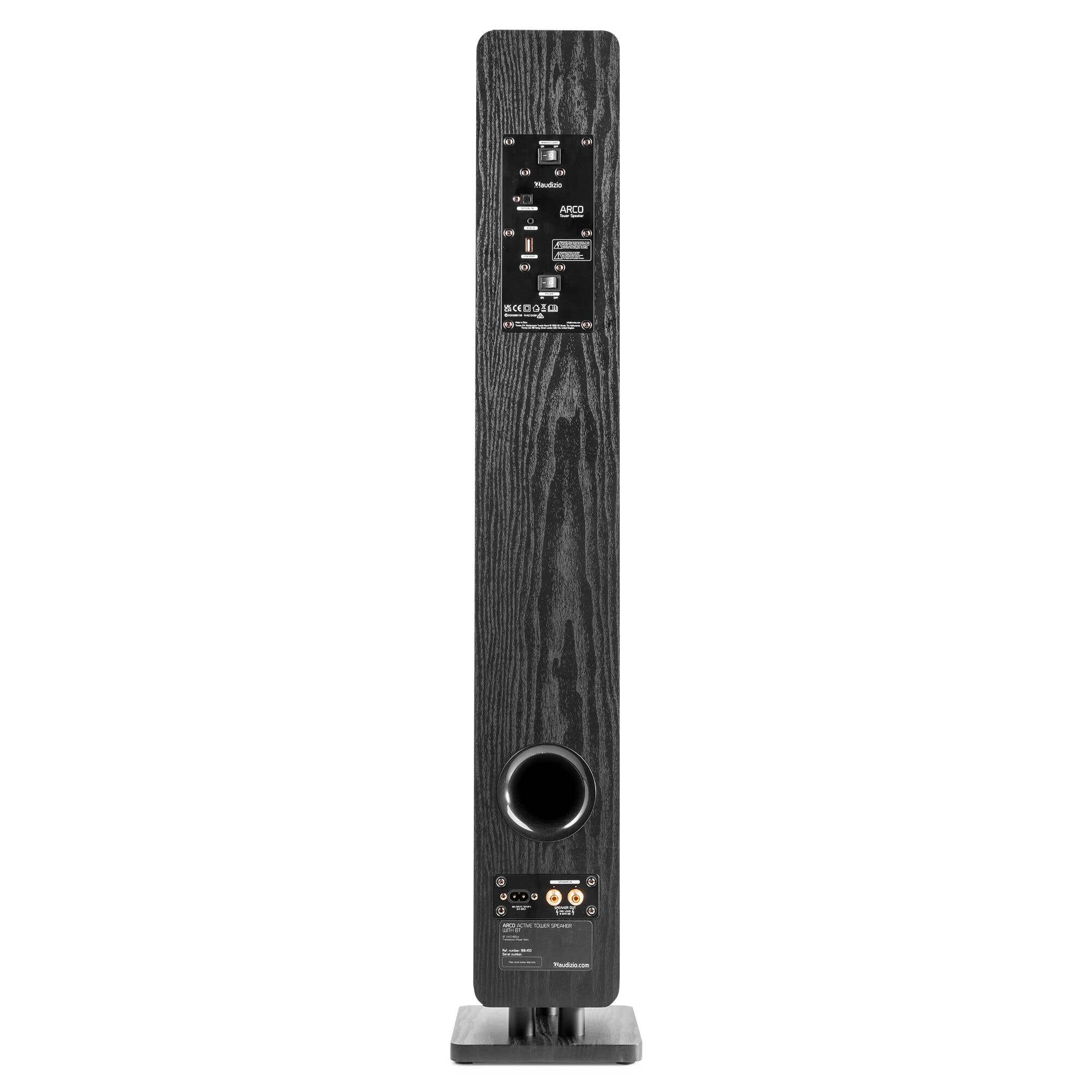 Vista trasera de un altavoz de torre de madera negra con conexiones e interruptores.