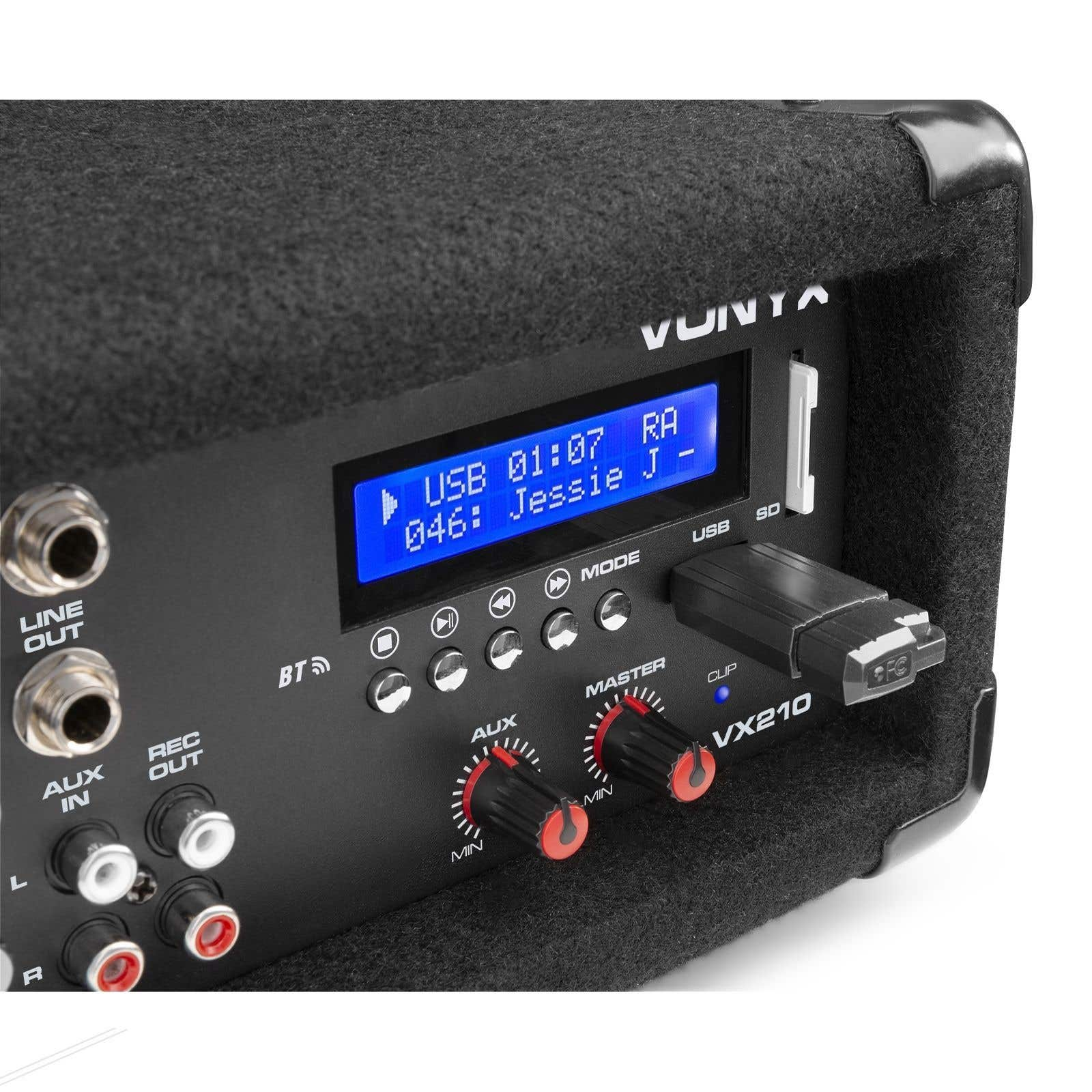 Una memoria USB está conectada a un altavoz con pantalla LCD azul y perillas.
