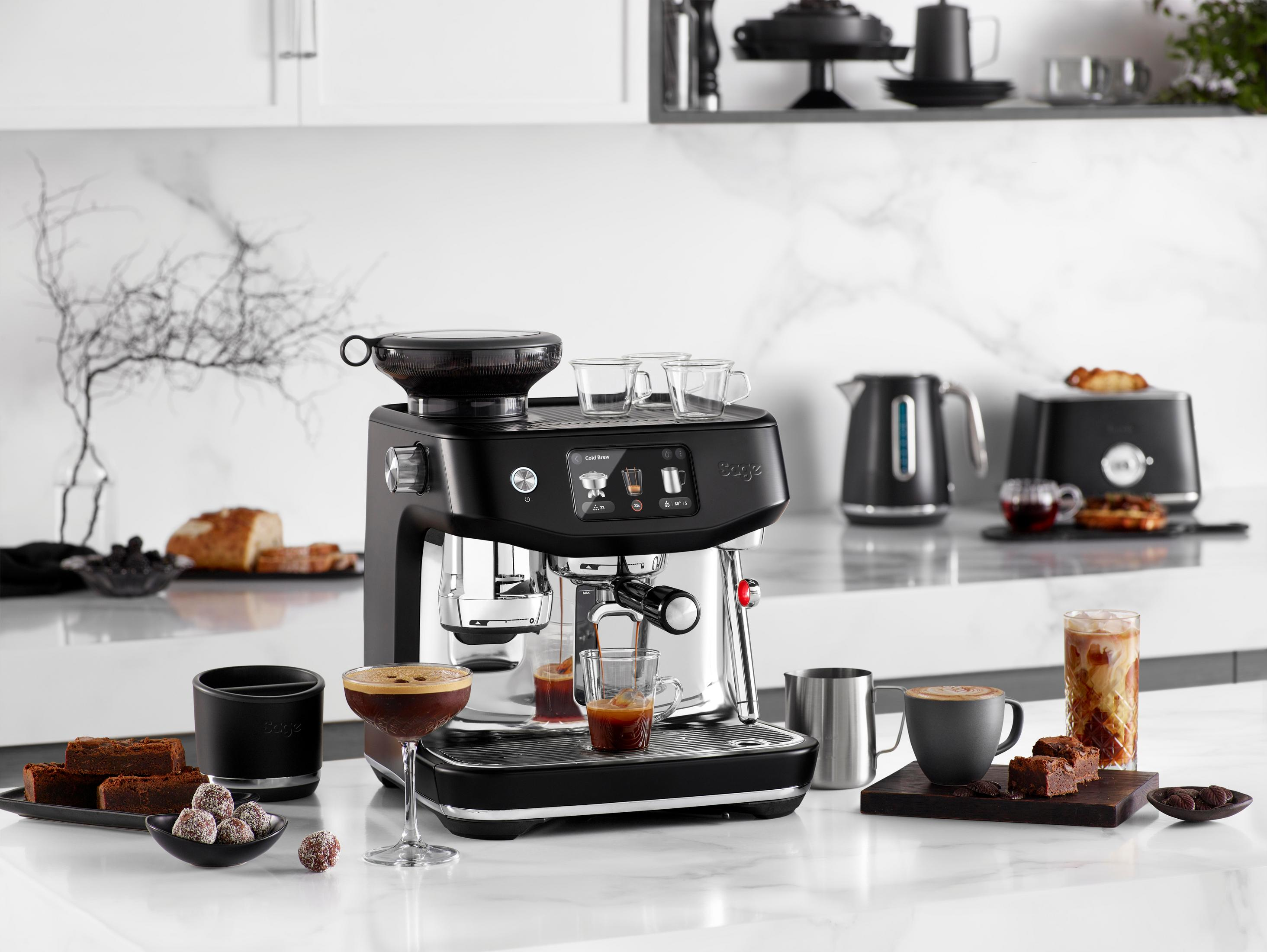 Una macchina per espresso con tazze da caffè, pasticcini e bevande su una superficie di marmo.