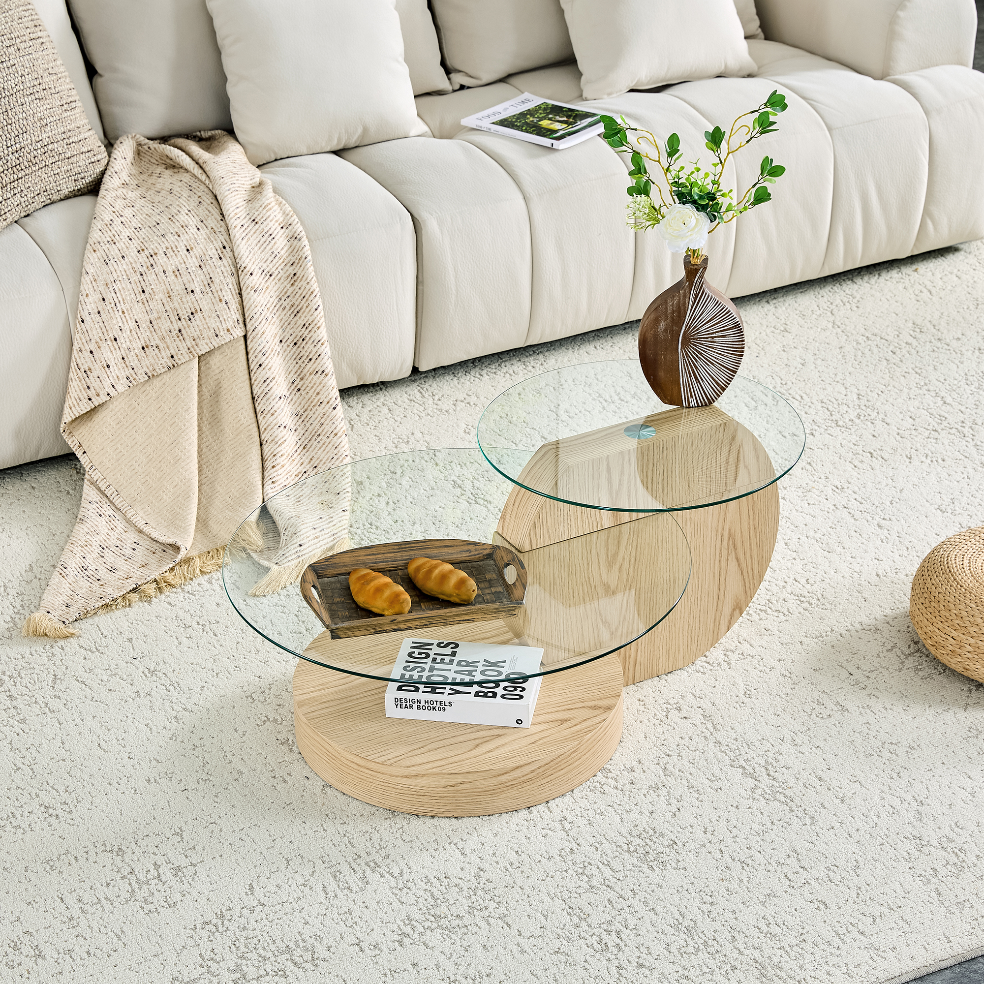 Ein helles Wohnzimmer mit einem beigen Sofa, einem Couchtisch und einem Teppich.