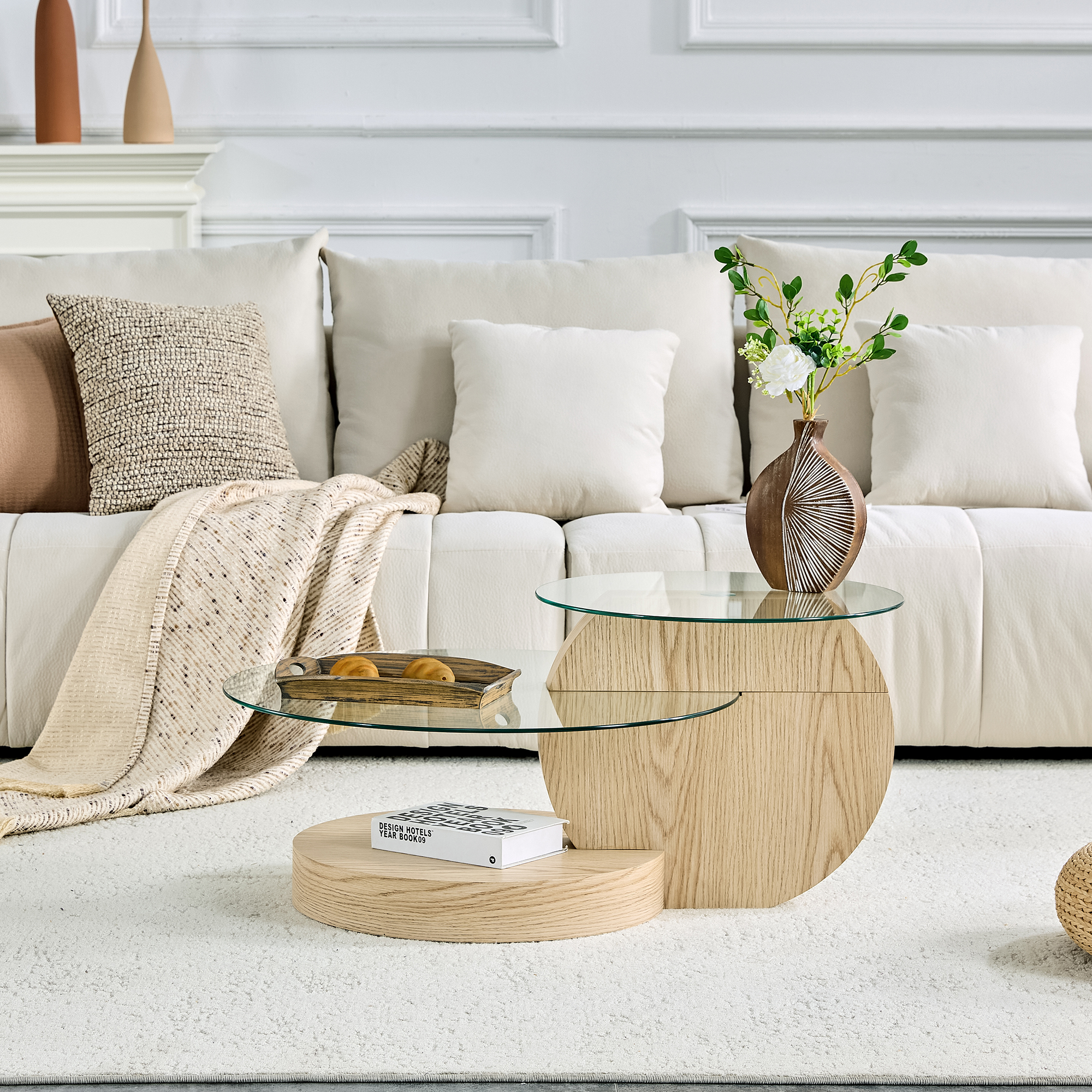Ein Wohnzimmer mit einem weißen Sofa, einem Glastisch mit Holzsockel und Dekoration.