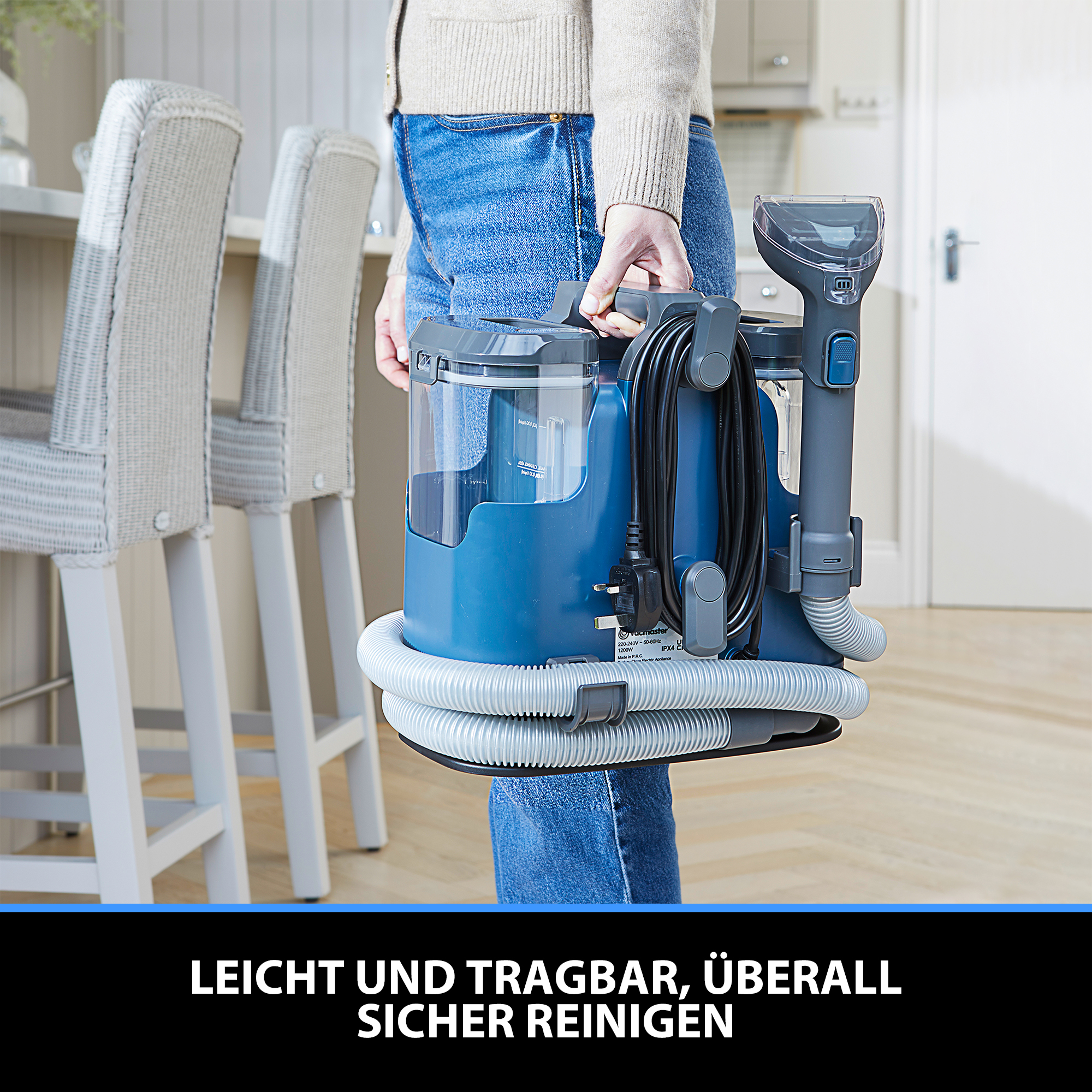 Eine Person hält einen blauen und grauen Reinigungsgerät mit Schlauch.