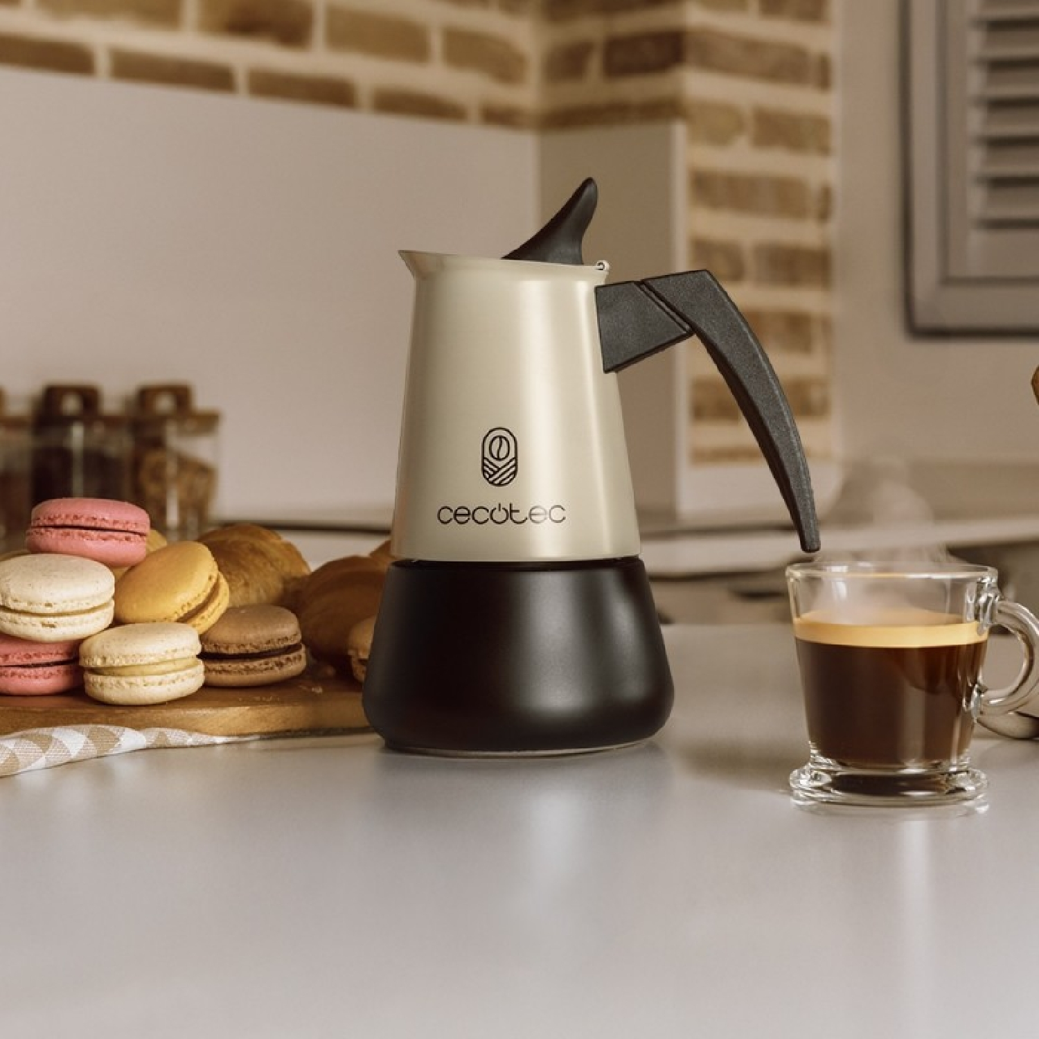 Eine weiße Kaffeemaschine mit einem Glas Kaffee und Macarons.
