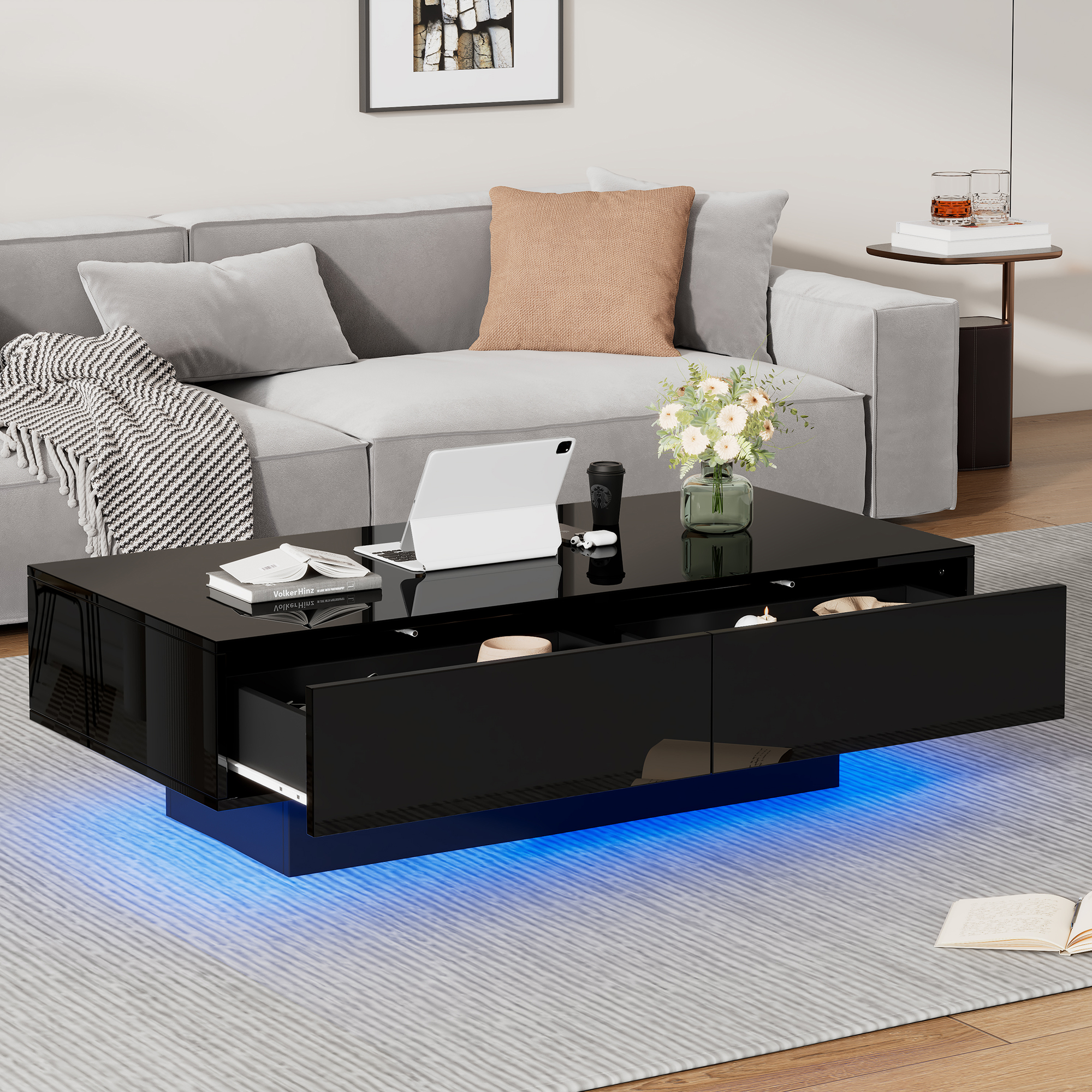 Moderner schwarzer Couchtisch mit blauer LED-Beleuchtung, geöffneten Schubladen und Laptop.