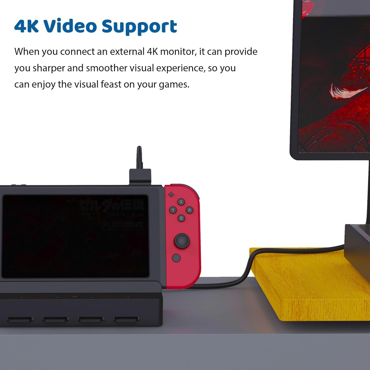 Ein roter Controller ist an einem schwarzen Dock angeschlossen. Ein Monitor zeigt ein Spiel.