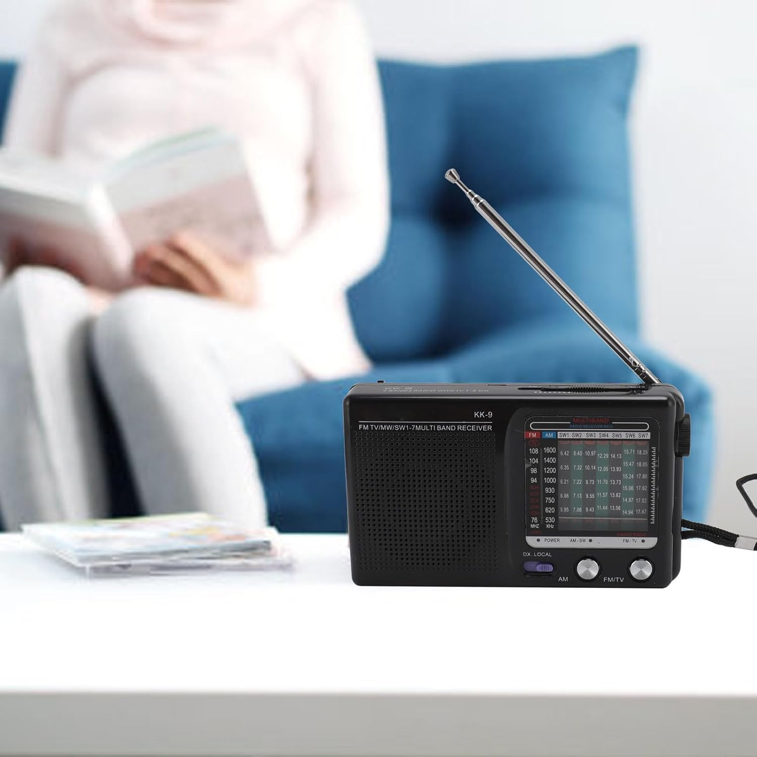 Ein schwarzes Multibandradio mit ausgefahrenem Antenne steht auf einem Tisch.