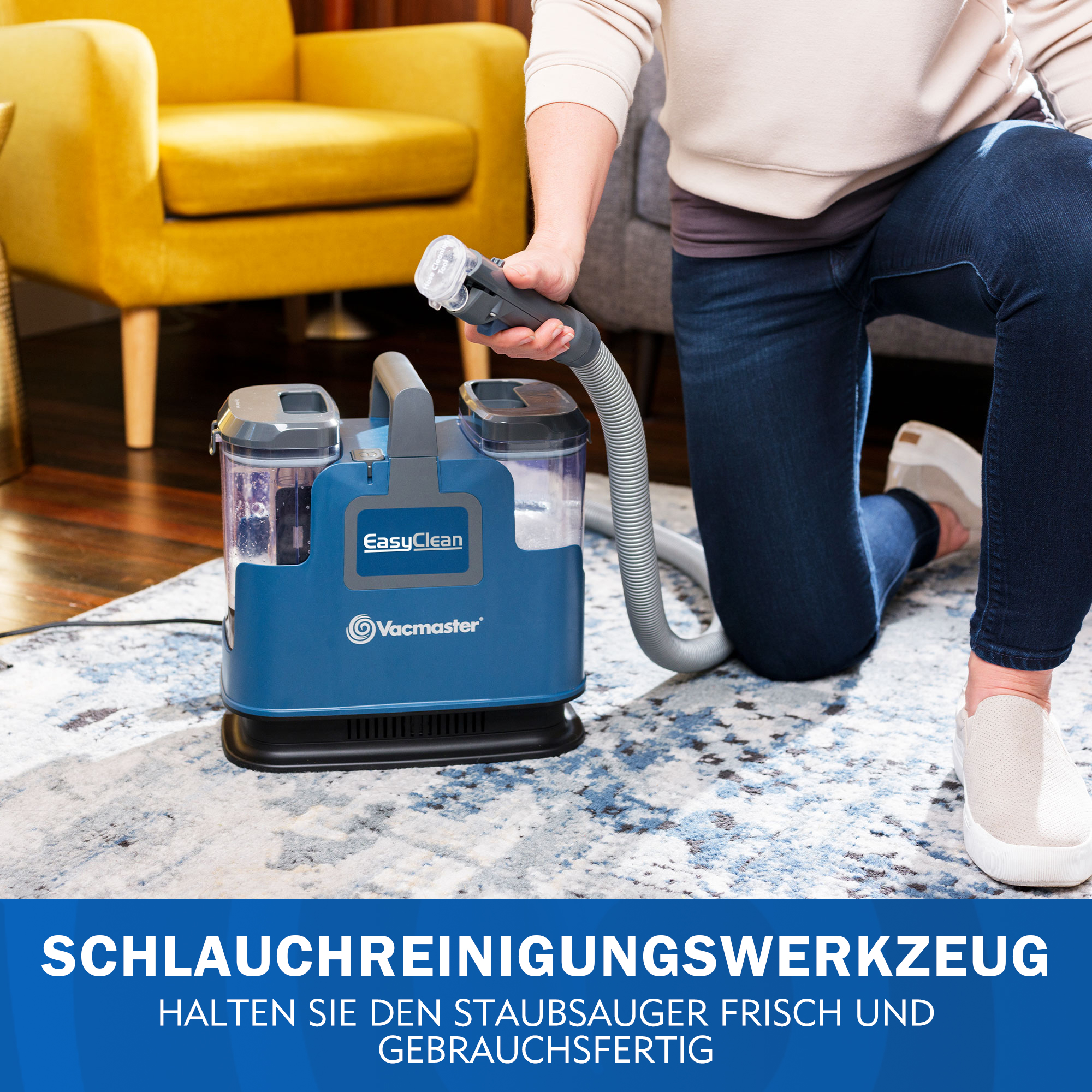 Ein blauer Nasssauger mit Schlauch, der von einer Person gehalten wird, die auf dem Teppich kniet.