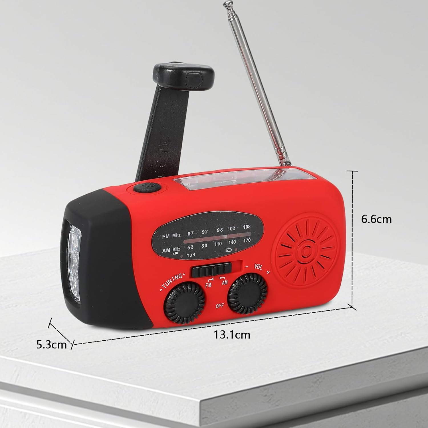 Ein rotes Notfallradio mit Kurbel, Taschenlampe und Antenne.