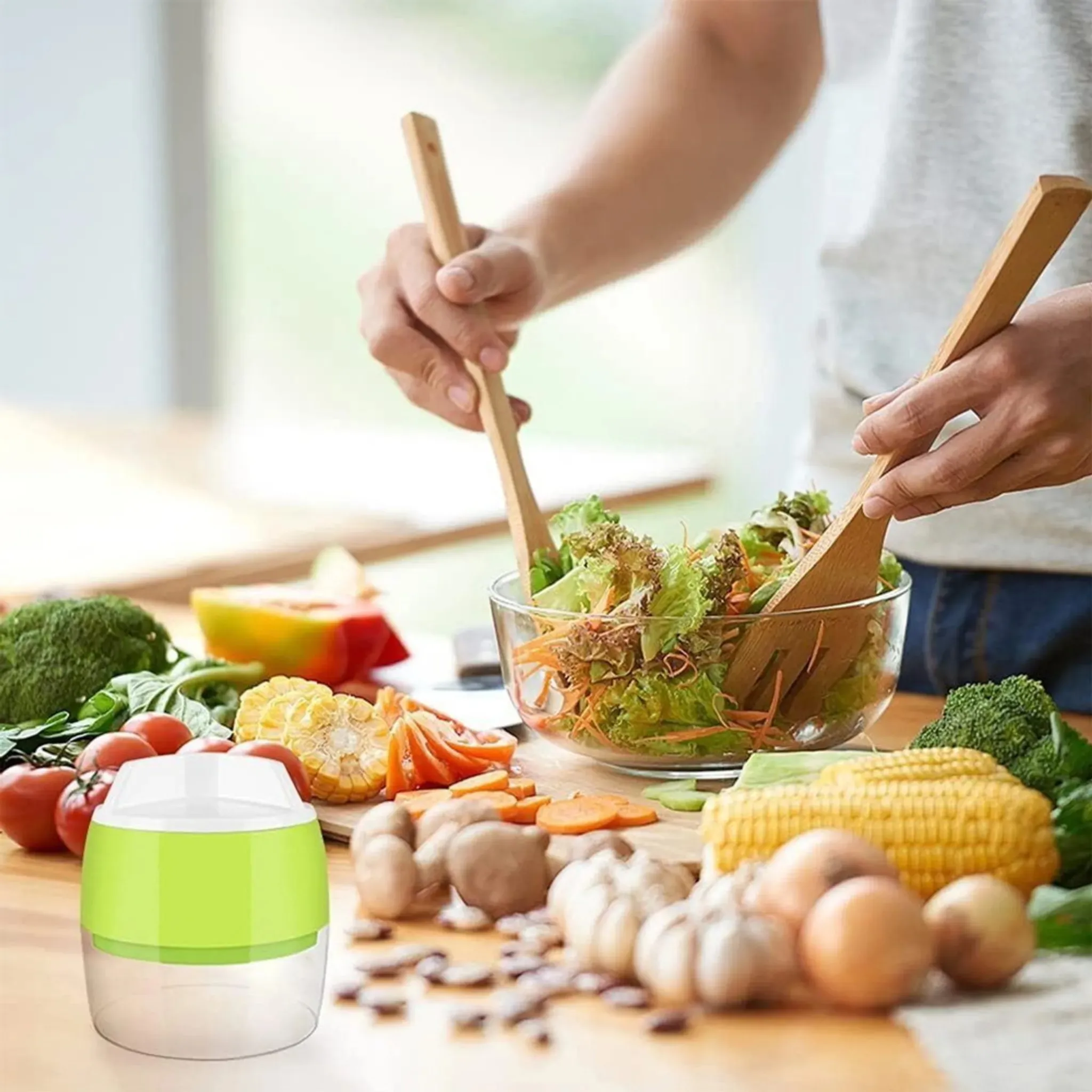 Person mixt Salat mit Holzutensilien, umgeben von Gemüse wie Mais und Tomaten.