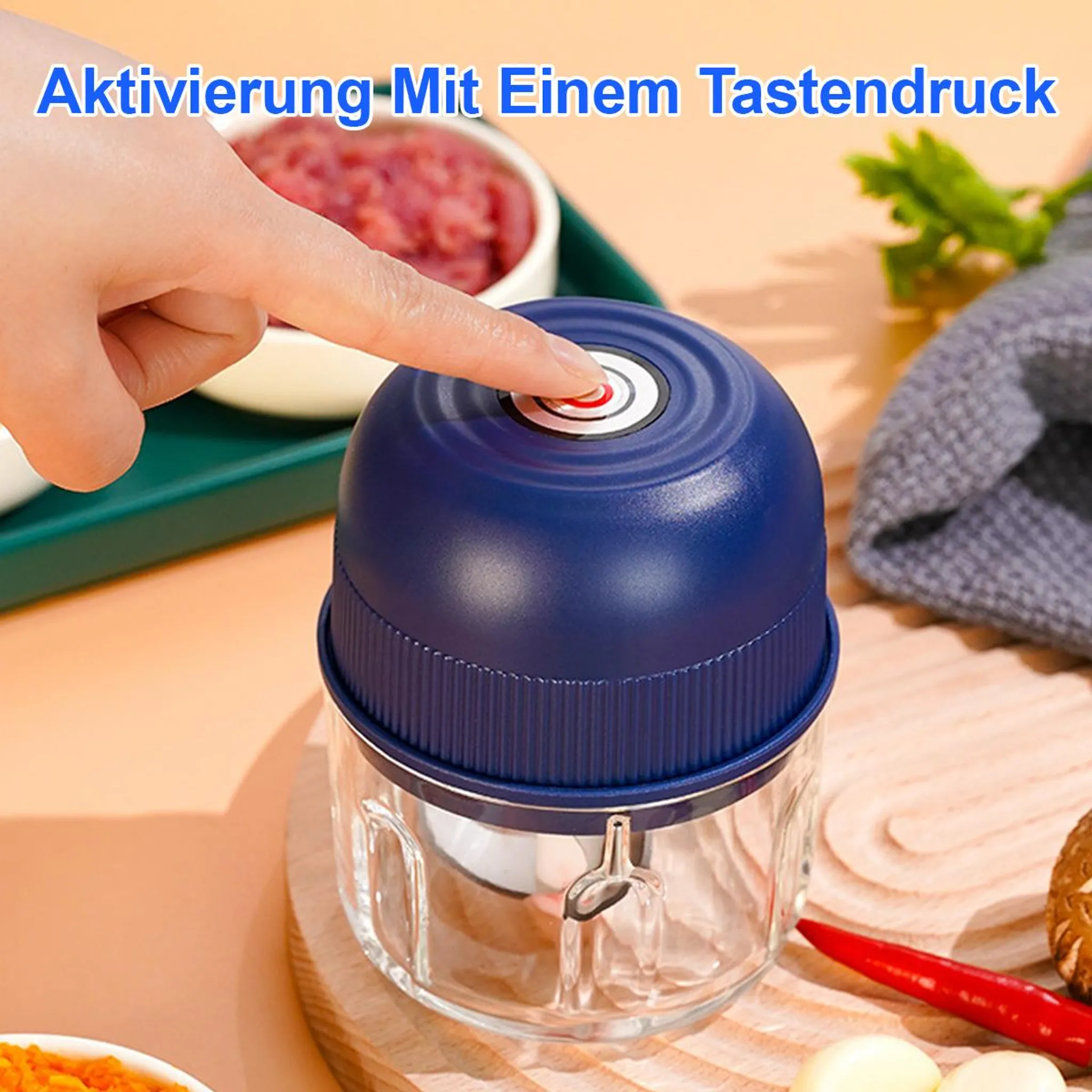 Finger drückt roten Knopf auf blauem Zerkleinerer neben Lebensmitteln.