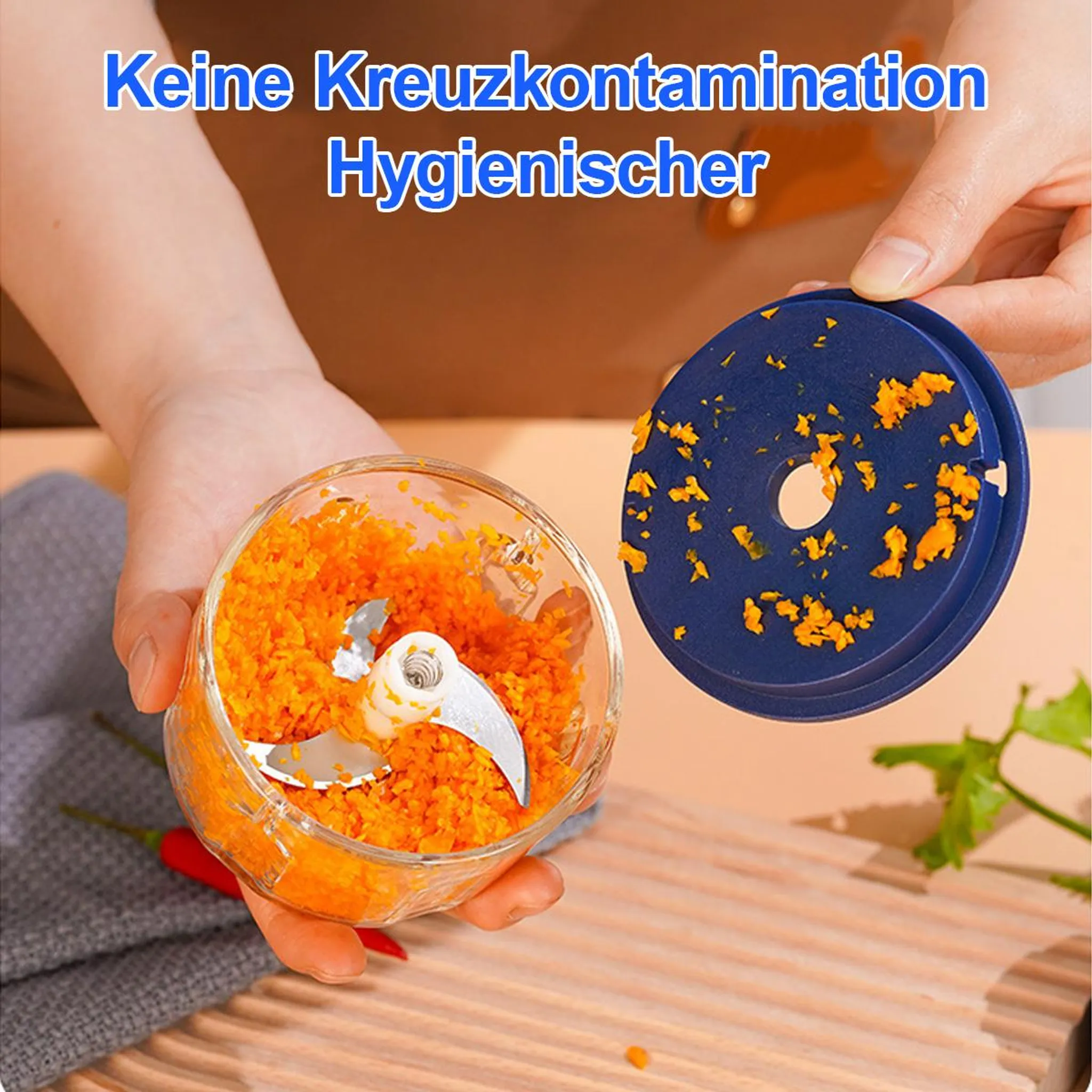 Eine Hand hält einen zerkleinerten Karotten-Füllstoff mit Klingen. Ein blauer Deckel liegt daneben.