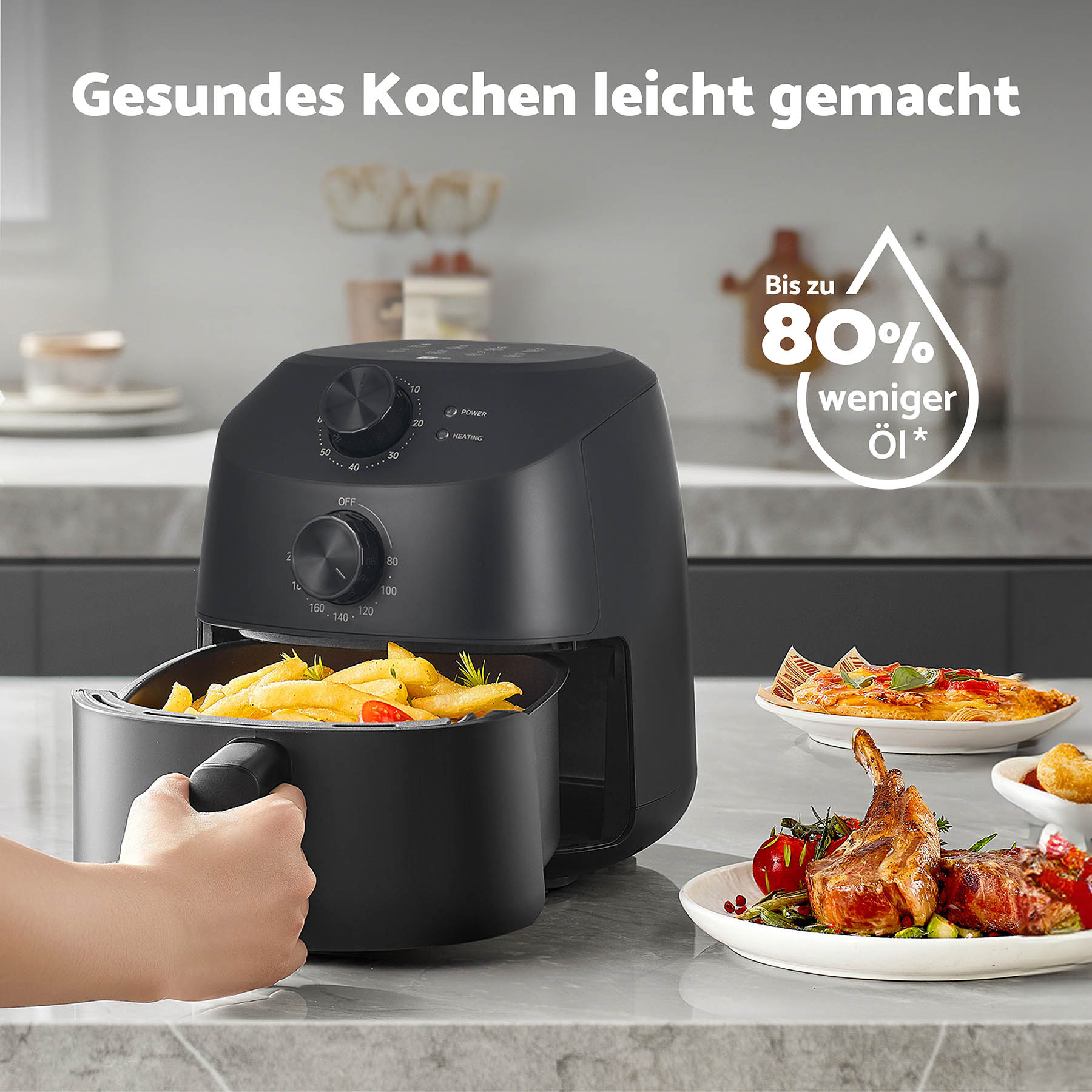 Eine schwarze Heißluftfritteuse mit Pommes im Korb und Essen auf Tellern daneben.