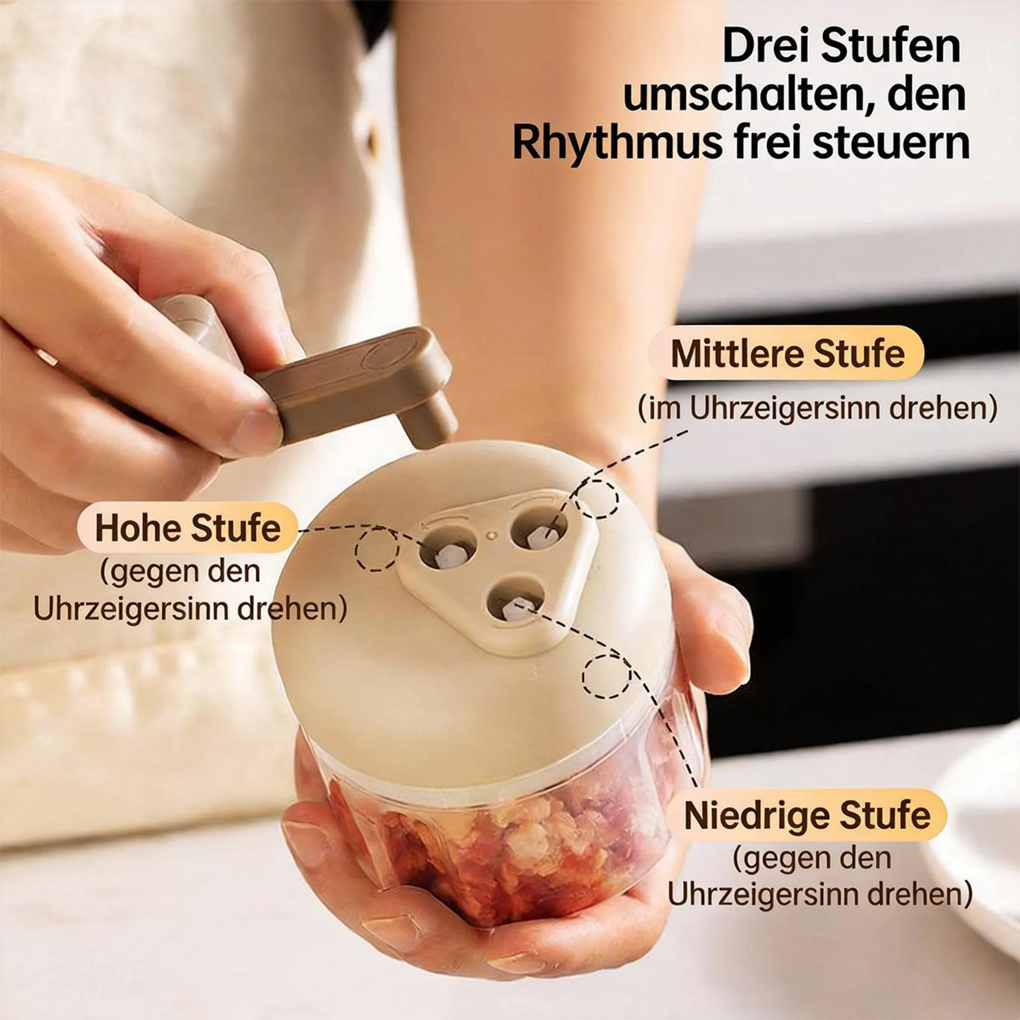 Manuelle Reibe mit drei Stufen zum Zerkleinern von Lebensmitteln, gehalten von einer Hand.