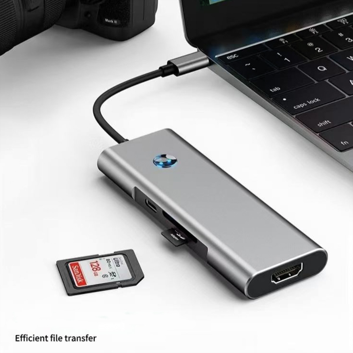 Ein silberner USB-C-Hub ist mit einem Laptop verbunden. Eine SD-Karte liegt davor.