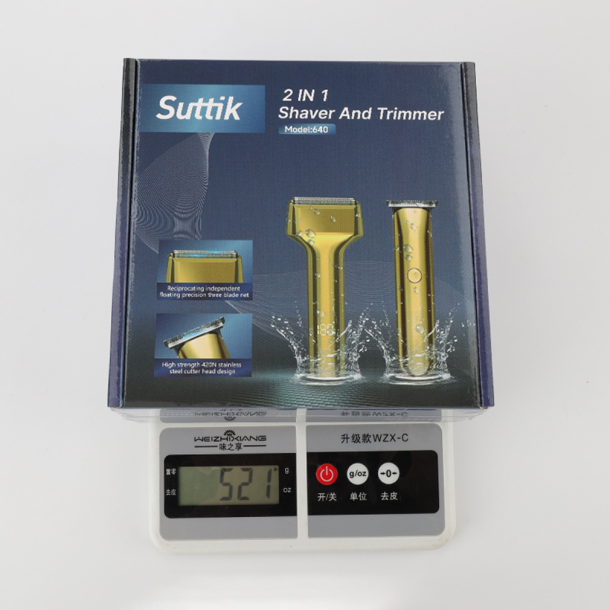 Goldene Suttik 2-in-1-Rasierer- und Trimmerbox auf einer Digitalwaage mit 521g.