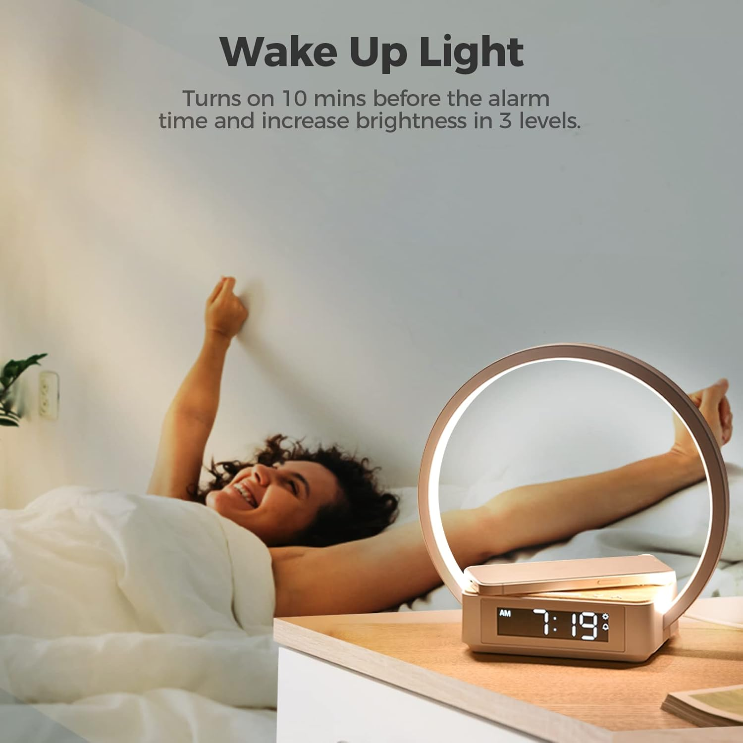 Eine Frau streckt sich im Bett, während eine Nachttischlampe mit Uhr und Handy-Ladegerät daneben steht.