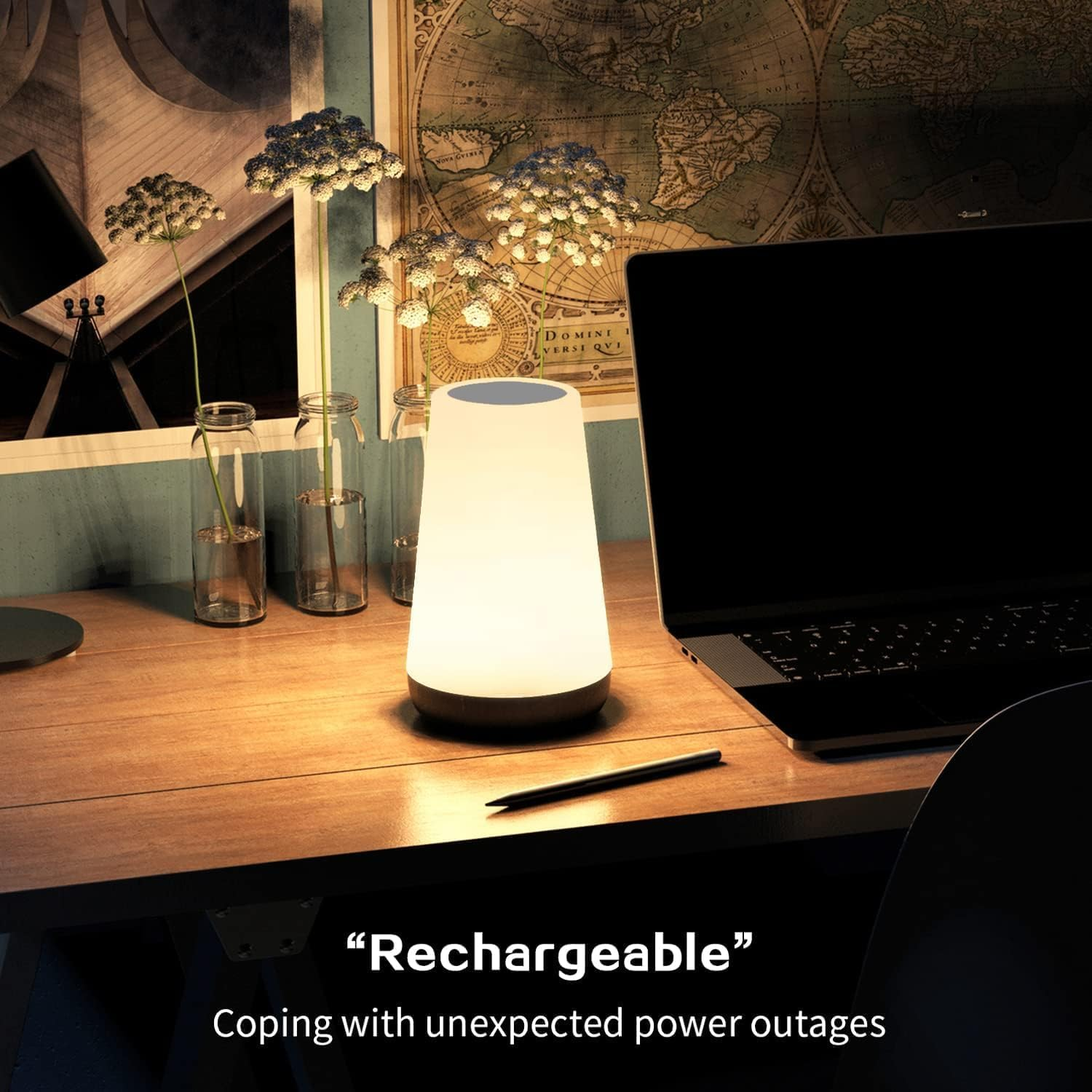 Eine leuchtende Lampe steht neben einem Laptop und einer Vintage-Karte auf einem Schreibtisch.