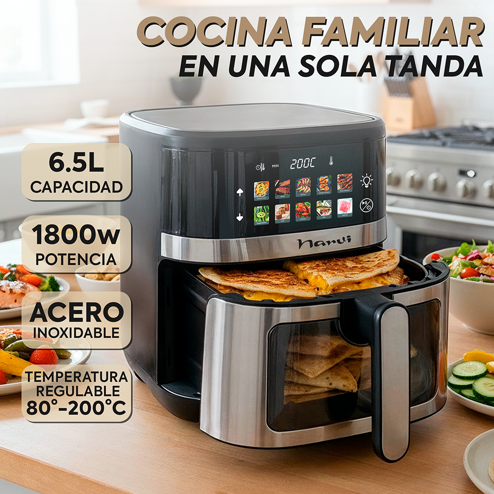 Una freidora de aire negra con quesadillas, junto a una ensalada y fruta.