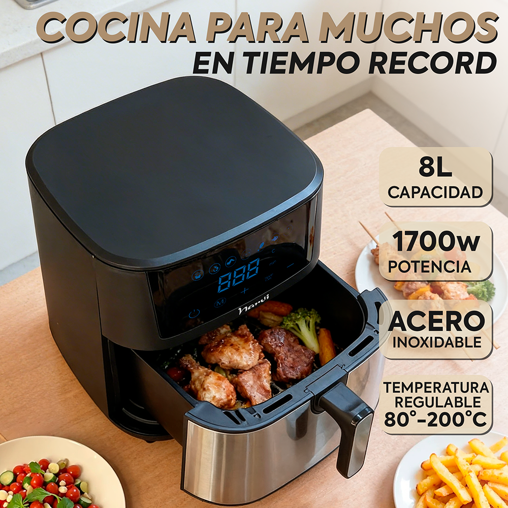 Freidora de aire negra con carne y verduras, junto a papas fritas y ensalada.