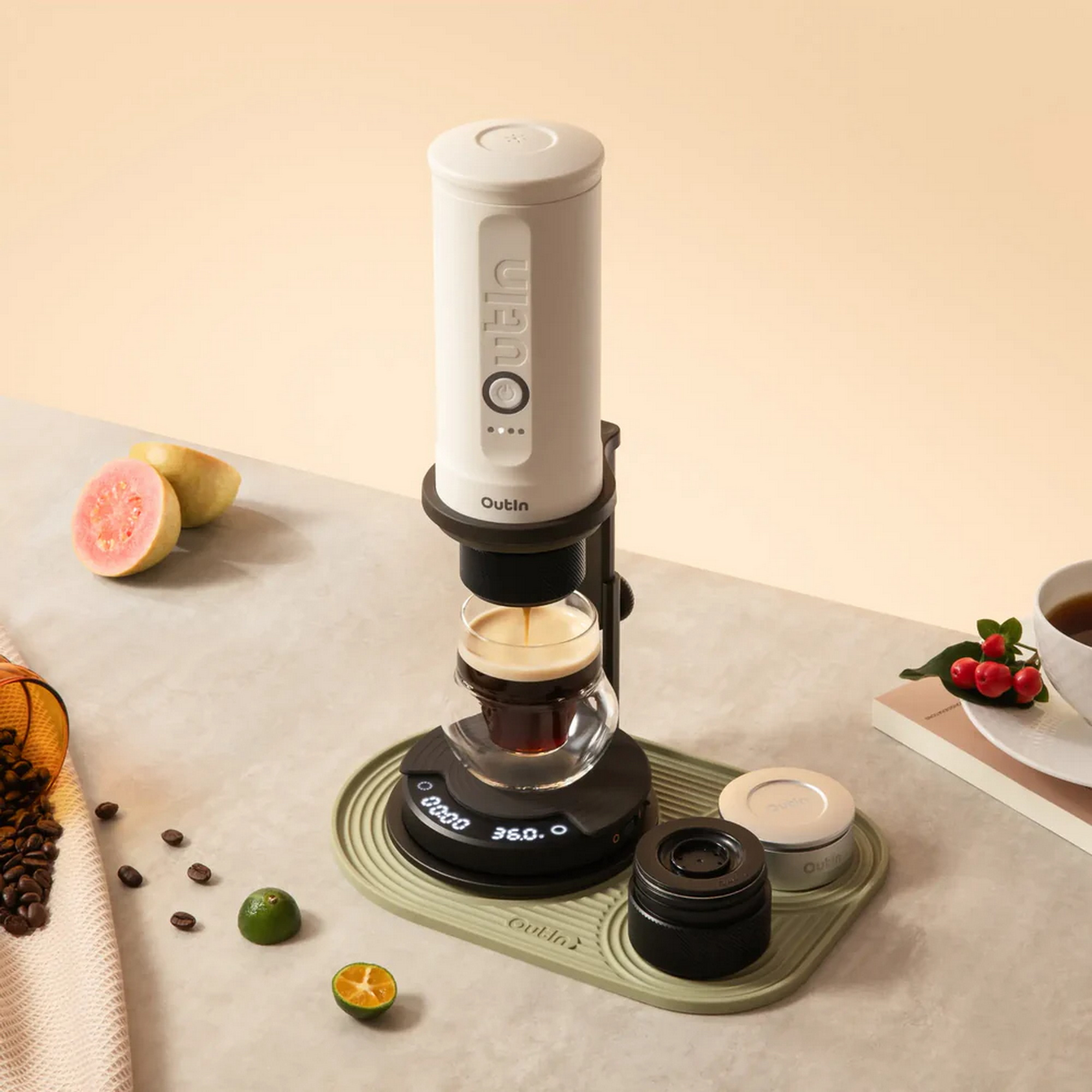 Een witte koffiemachine zet koffie in een glas op een weegschaal. Fruit & bonen ernaast.