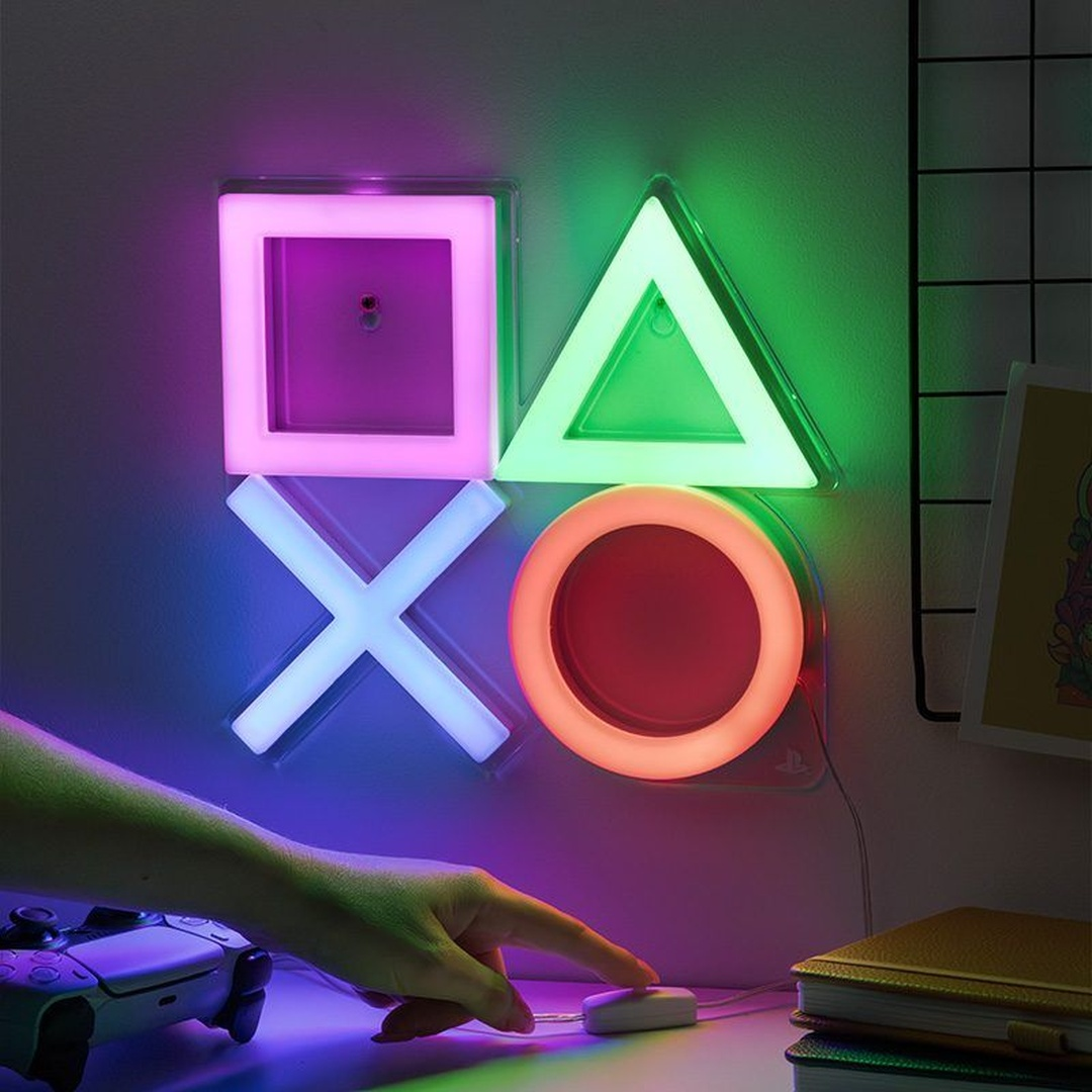 Neonowe symbole PlayStation świecą na różowo, zielono, niebiesko i pomarańczowo.
