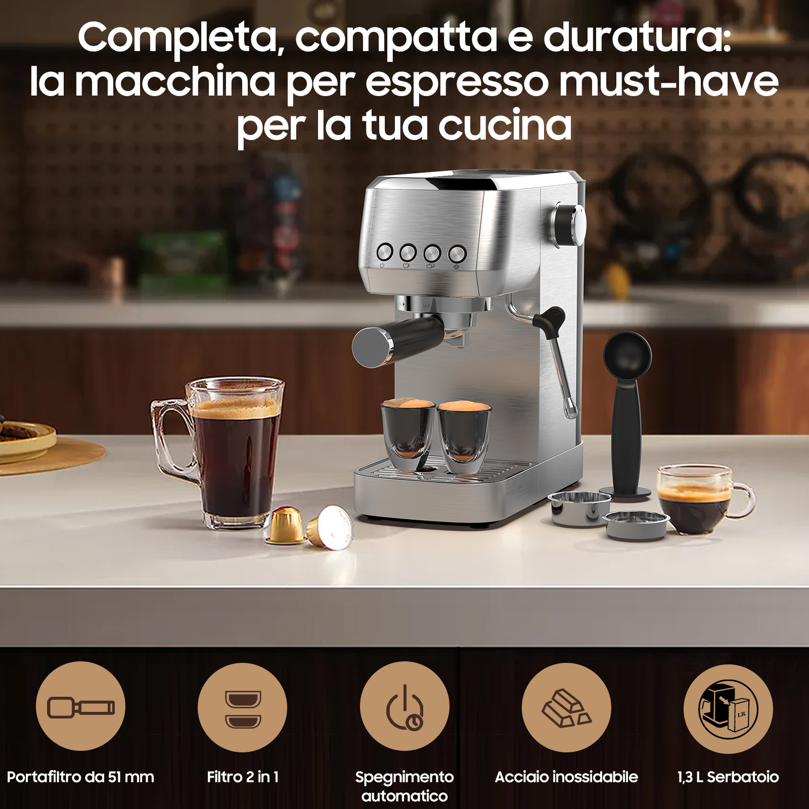 Macchina per espresso argentata con tazze, capsule e accessori su un piano di lavoro.
