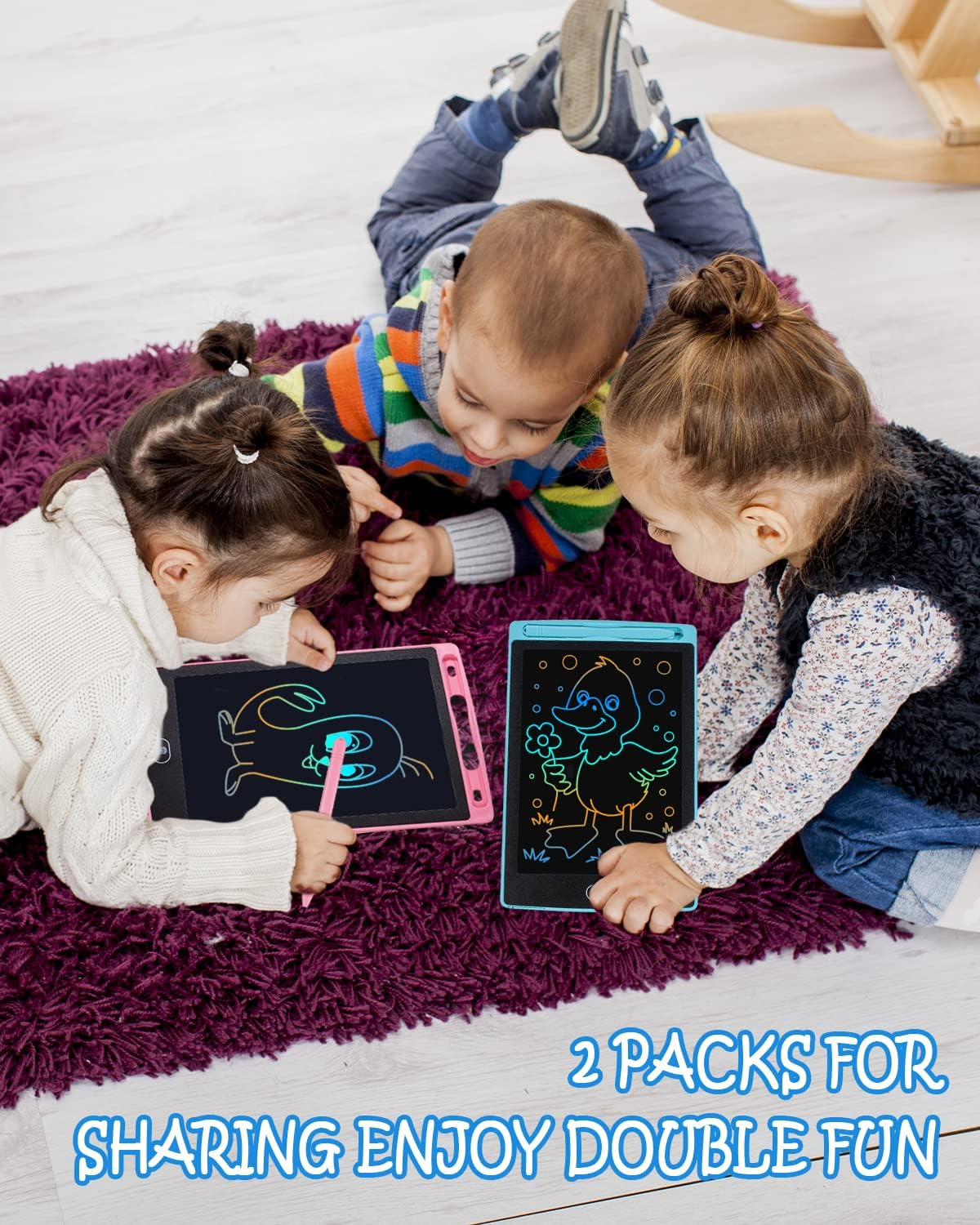 Drei Kinder liegen auf einem Teppich und malen auf digitalen Tafeln.