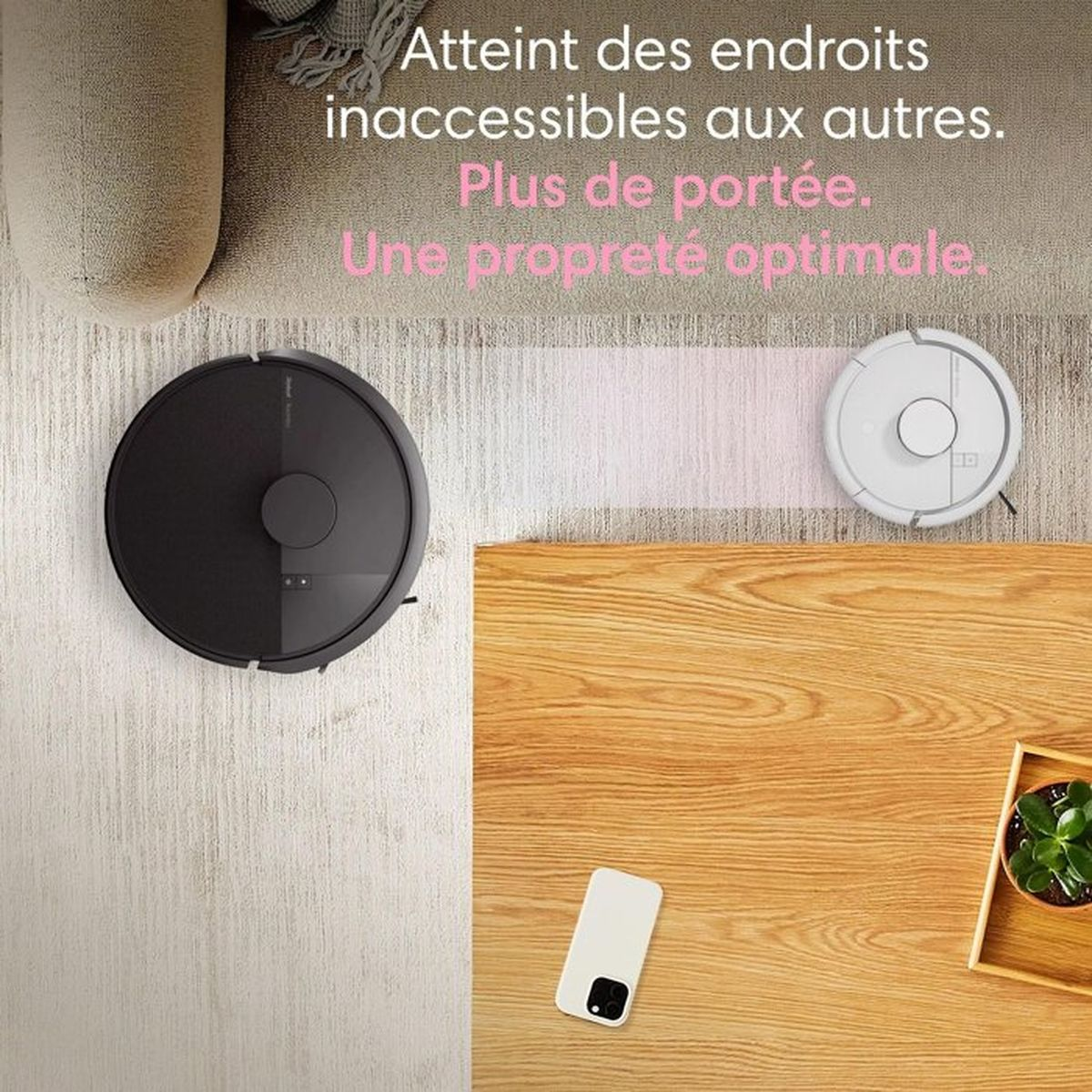 Due robot aspirapolvere, uno nero, uno bianco, su tappeto e tavolo di legno.